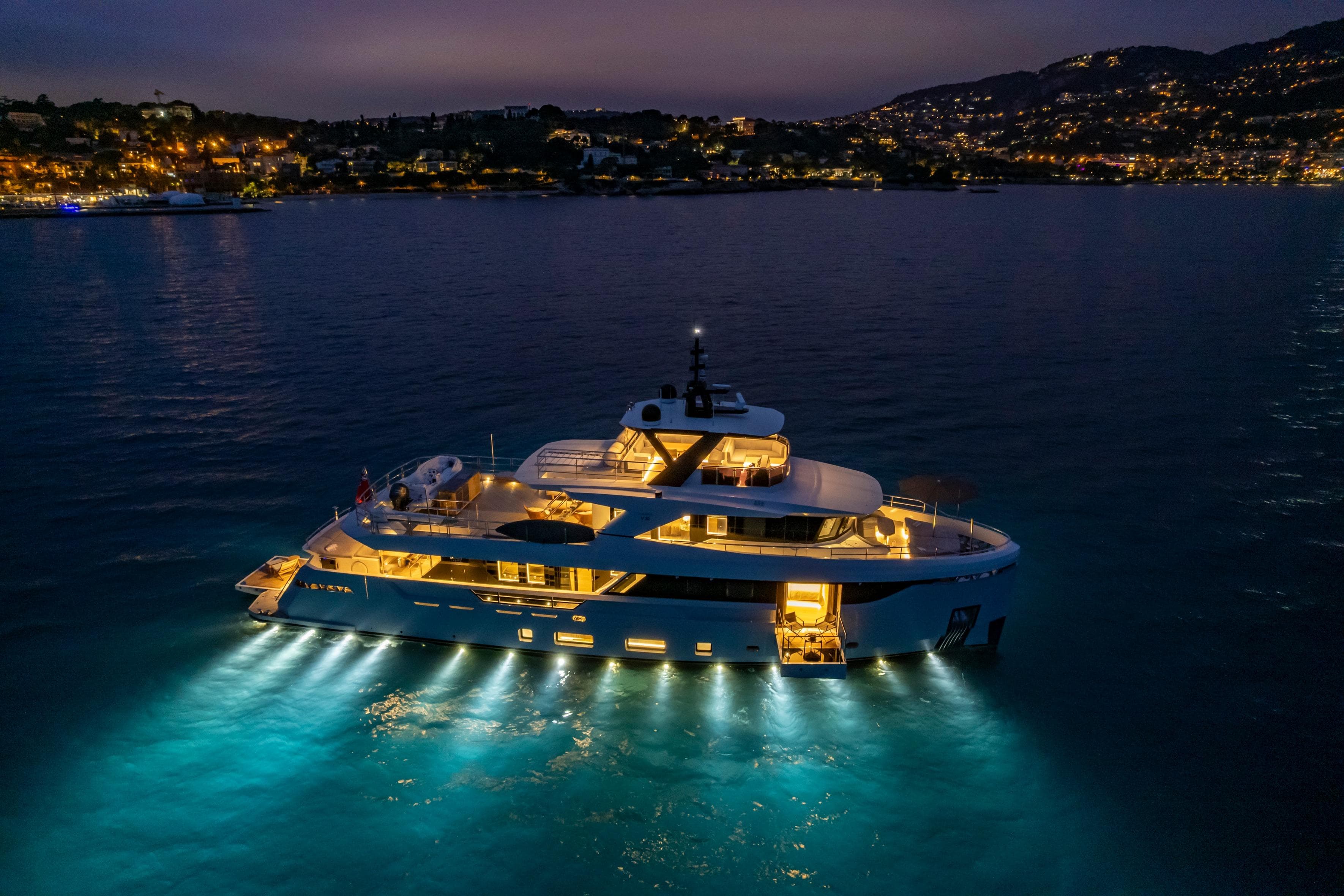Luxurious Blaundus V30 Explorer yacht illuminated at night on serene waters, 2023 model.