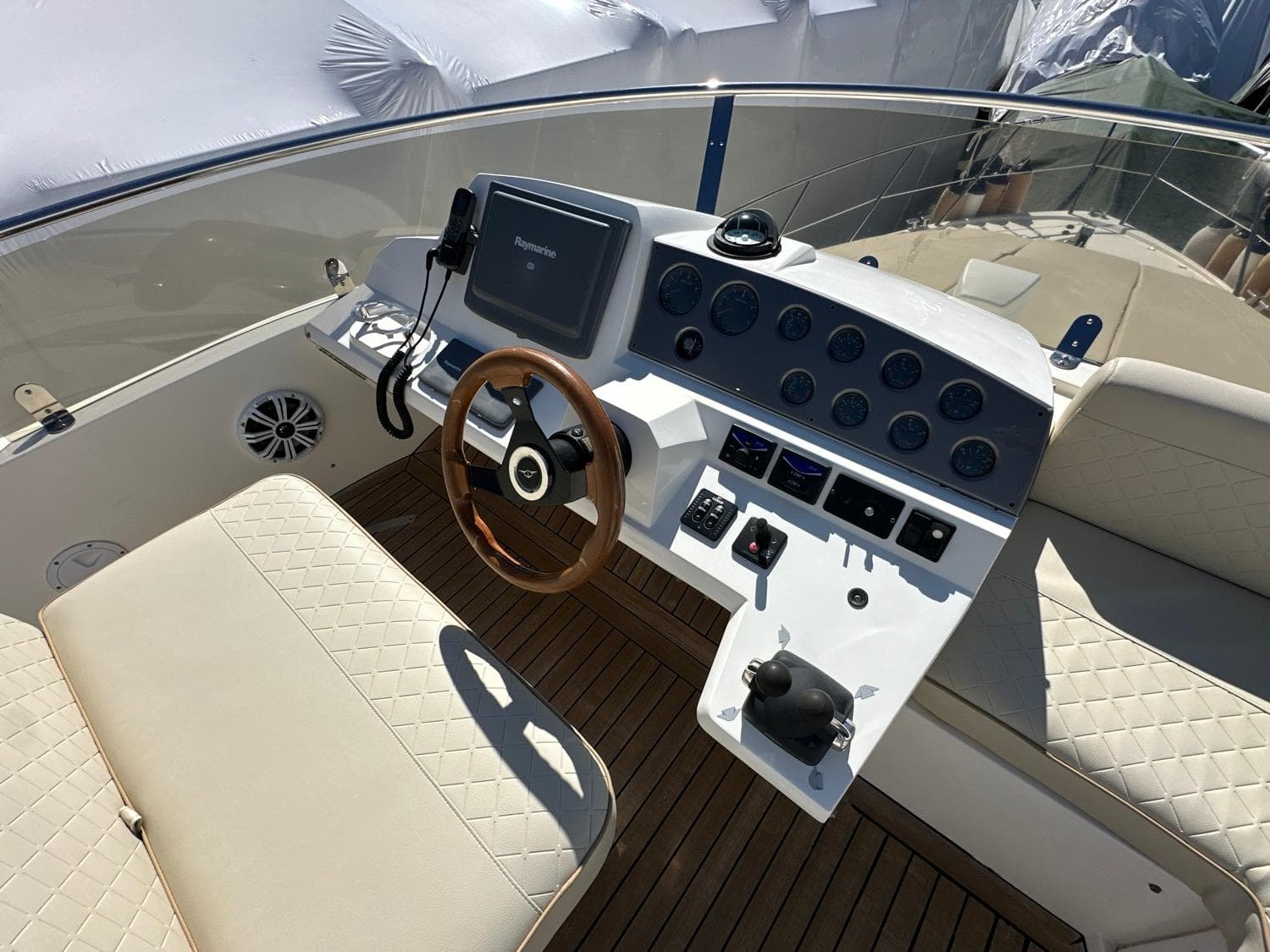 2007 Sealine F42/5 yacht helm with wooden steering wheel and modern navigation controls.