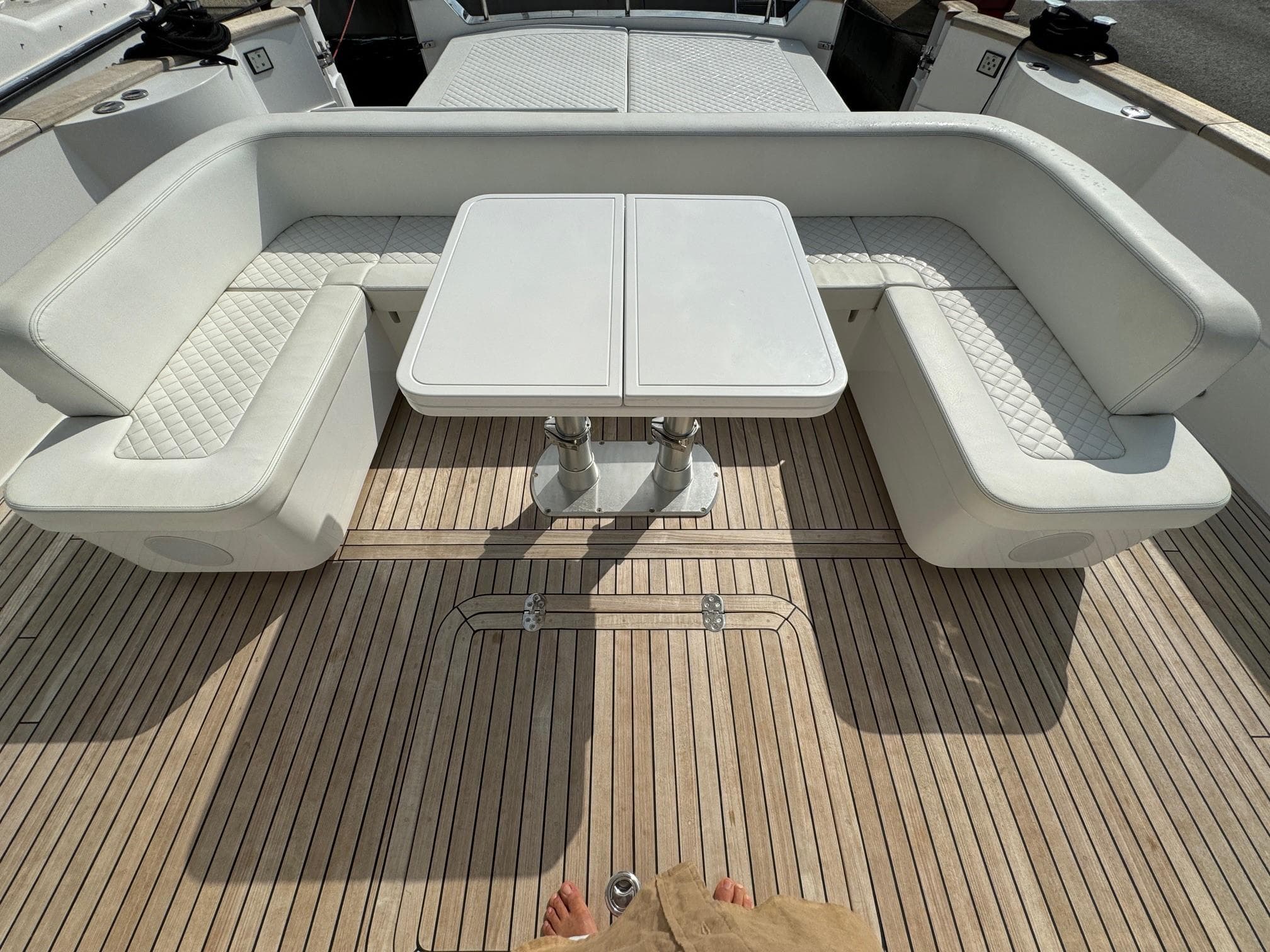 Luxury seating area on 2022 Apreamare Gozzo 45 yacht with white cushions and wooden deck.