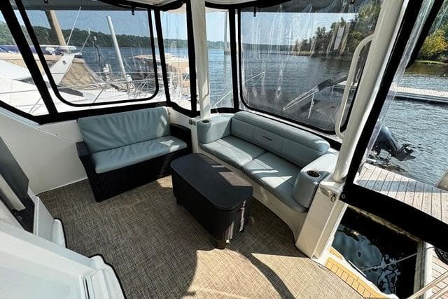 2004 Silverton 35 MY Aft Cabin Motoryacht interior with seating, docked by a scenic lake.