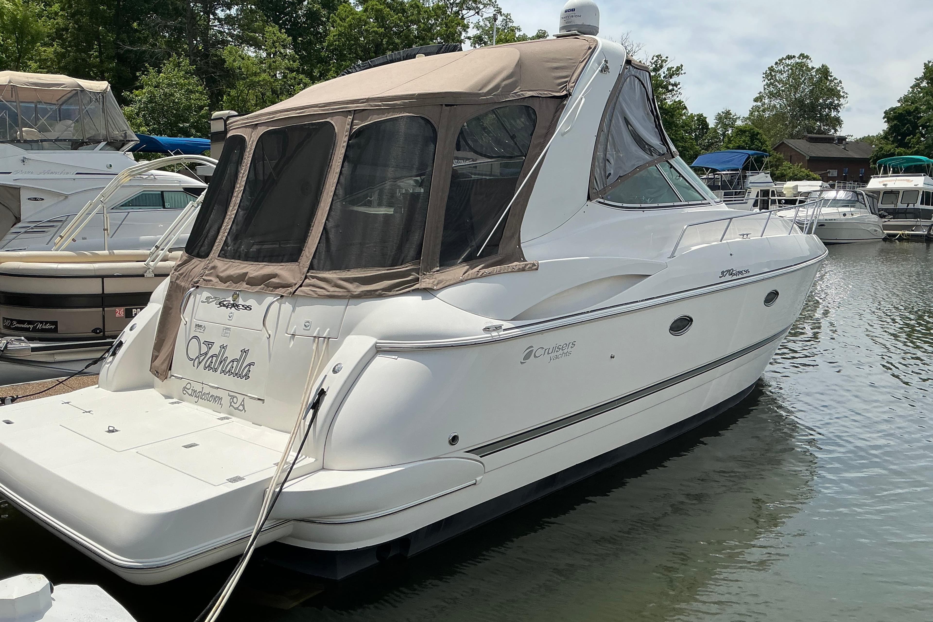 2005 Cruisers Yachts 370 Express docked in a marina, featuring sleek design and canopy.