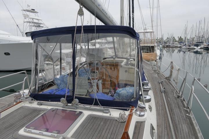 2006 Tayana 58 Deck Salon yacht docked at marina, featuring spacious deck and clear canopy.