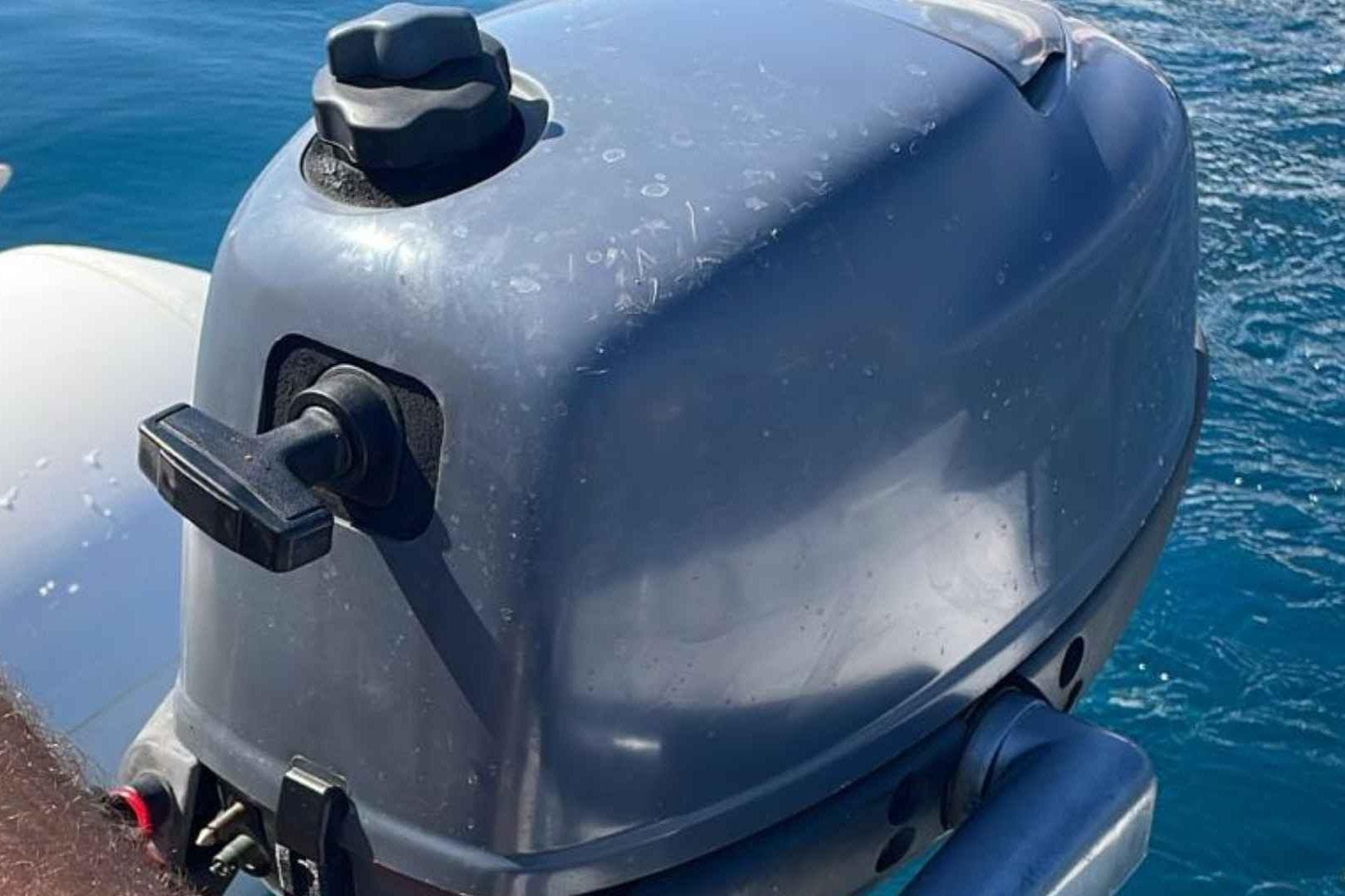 Outboard motor on a Princess V42 yacht, 2000 model, against a blue ocean backdrop.