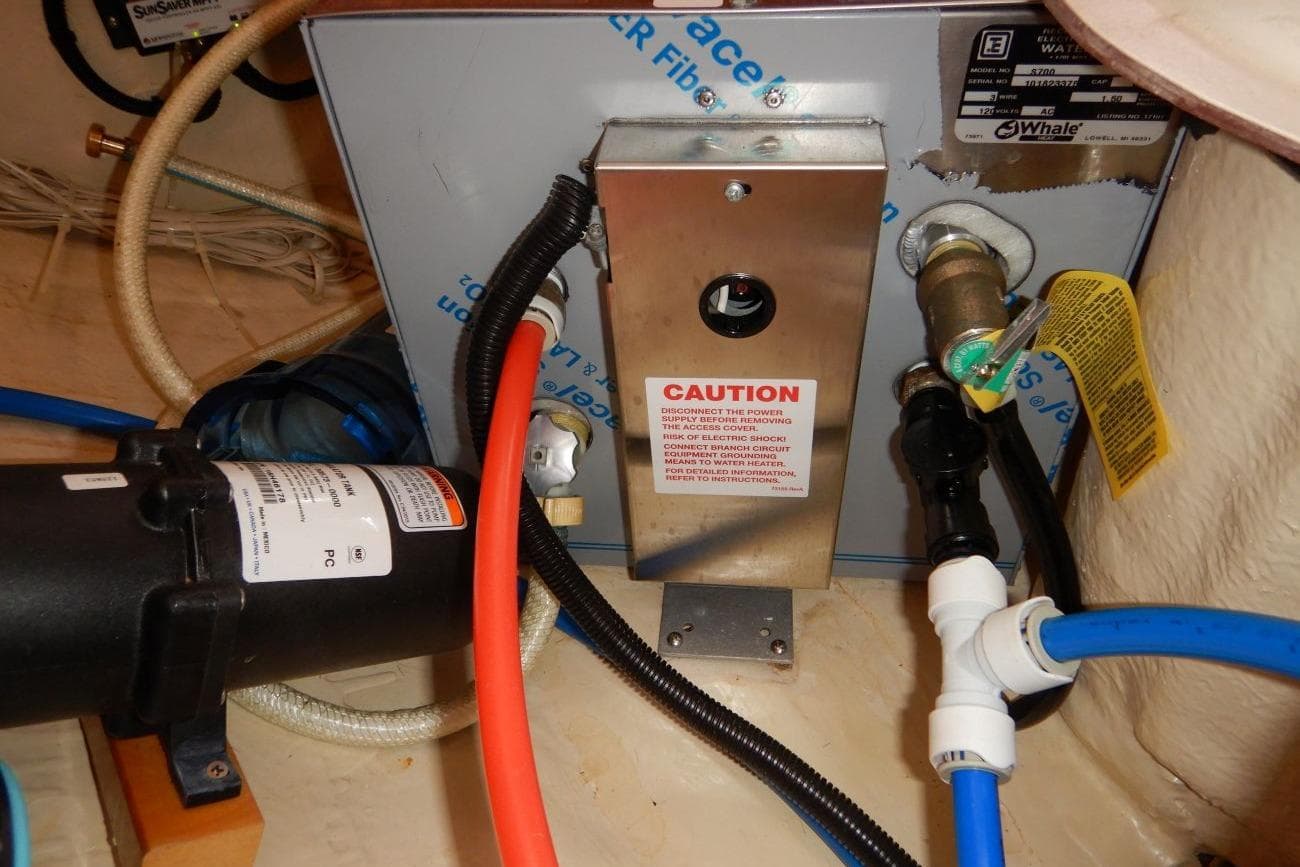 Boat engine compartment of a 2001 Hunter 320 with visible wiring and caution label.