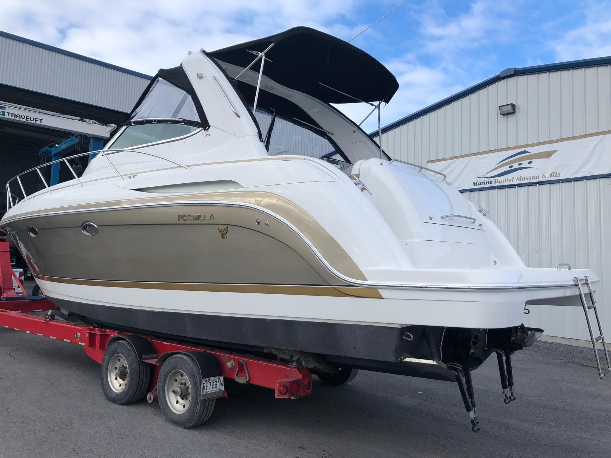 2004 Formula 37 Performance Cruiser on trailer, white and gold, docked at marina.