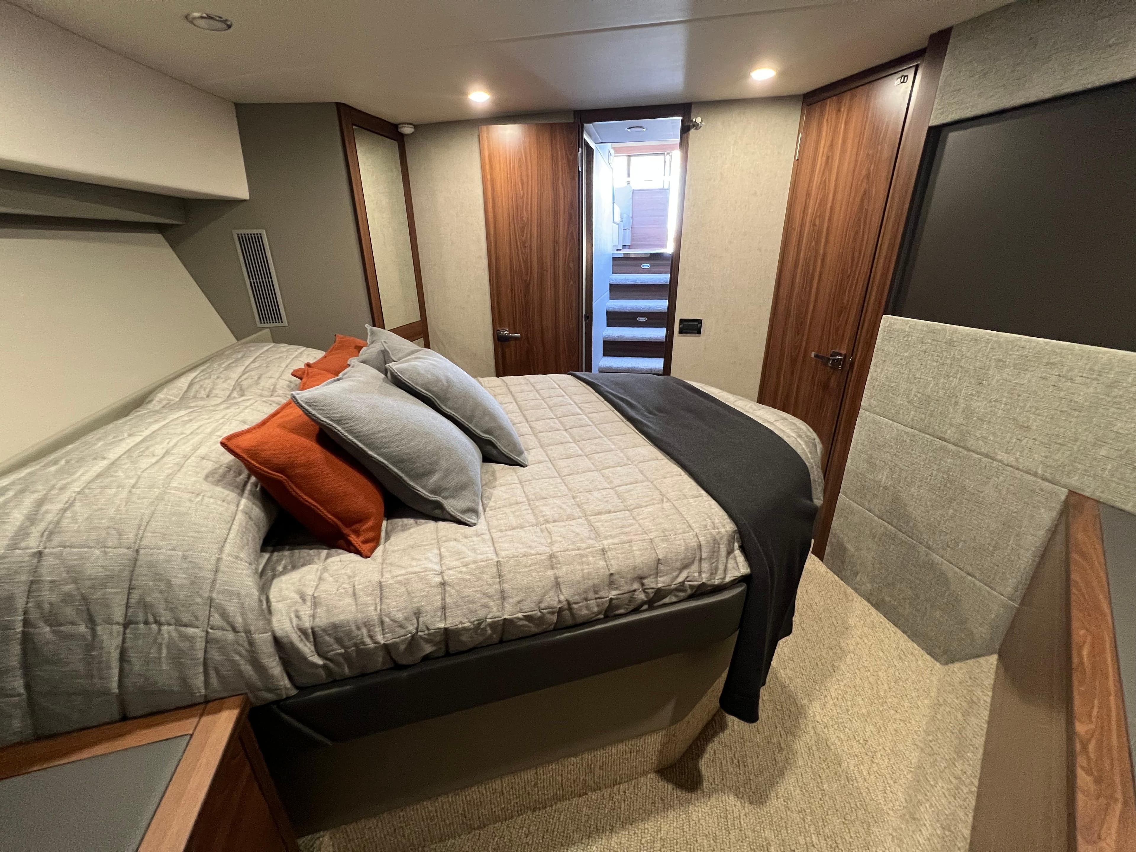 Luxurious bedroom interior of 2023 Maritimo M600 yacht with modern design and cozy bedding.