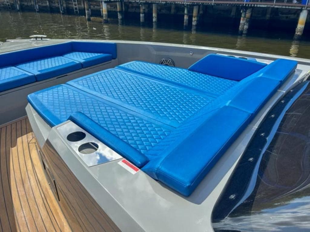 De Antonio Yachts D42 Open 2023 model with blue cushioned seating and sunbathing area.