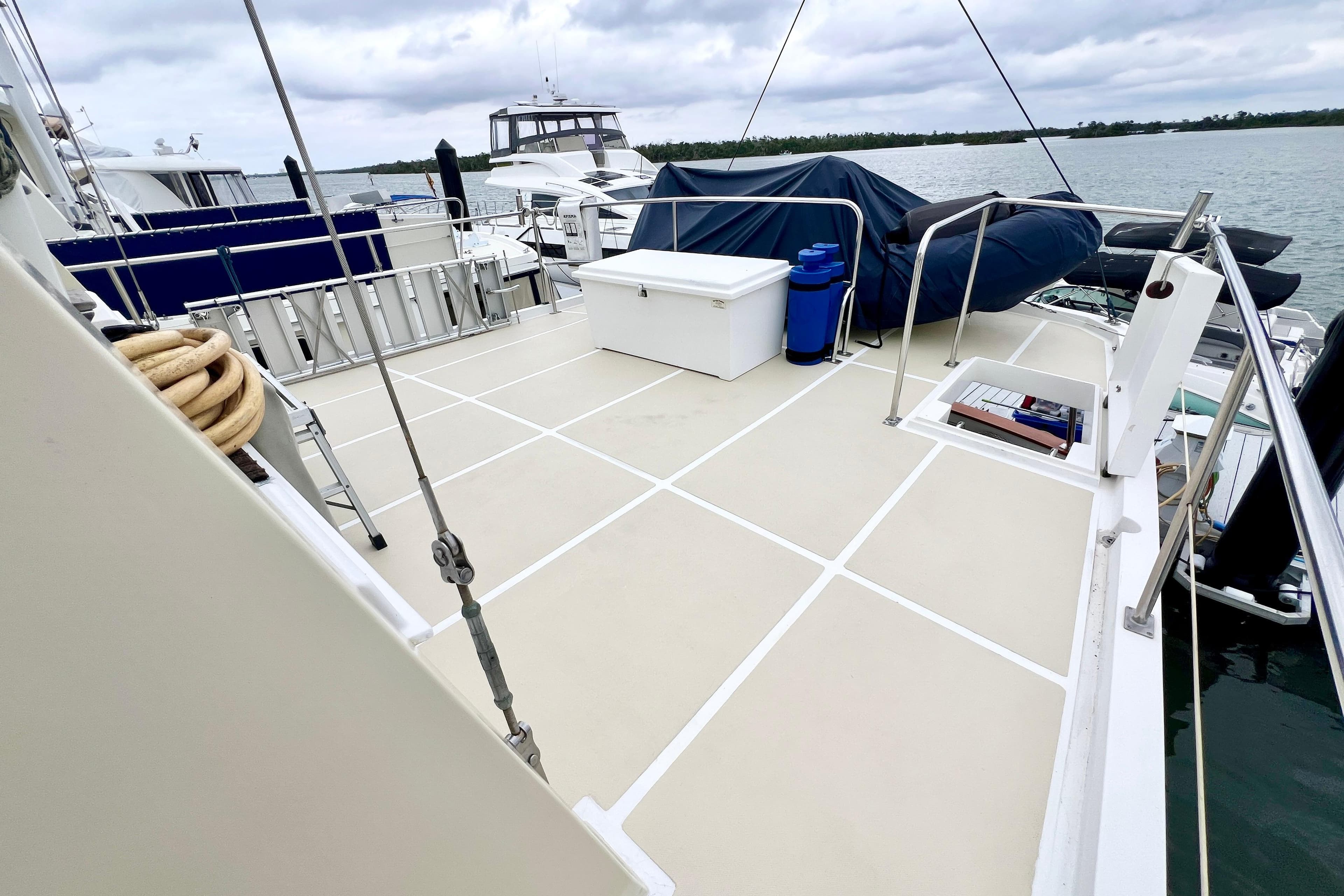 1996 Kadey-Krogen 48 Whaleback yacht deck with storage and railing, docked by the water.