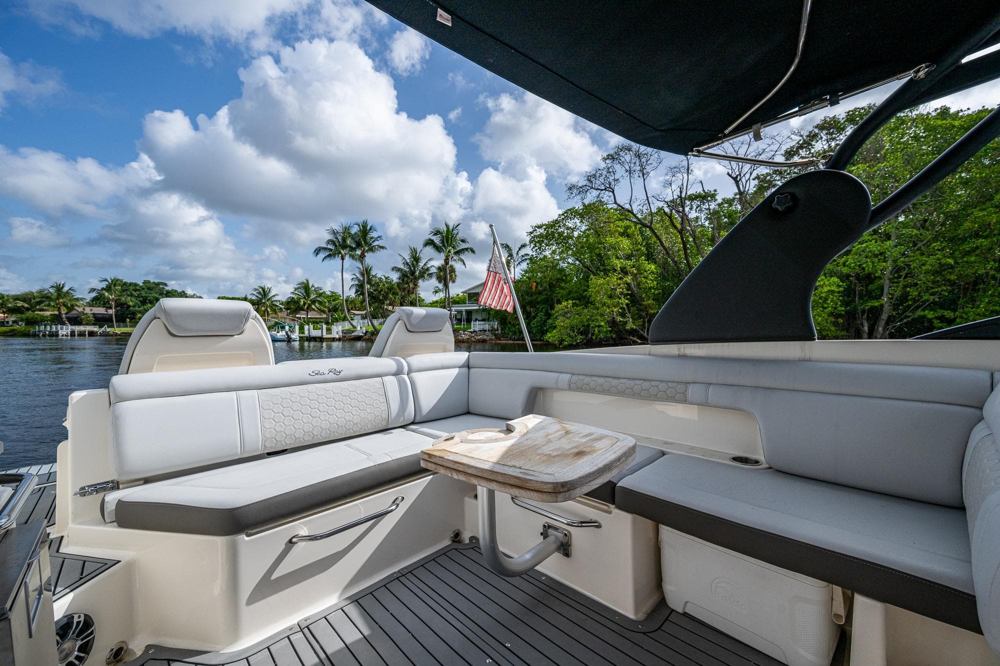 2022 Sea Ray SDX 290 boat interior with seating, table, and scenic water view.