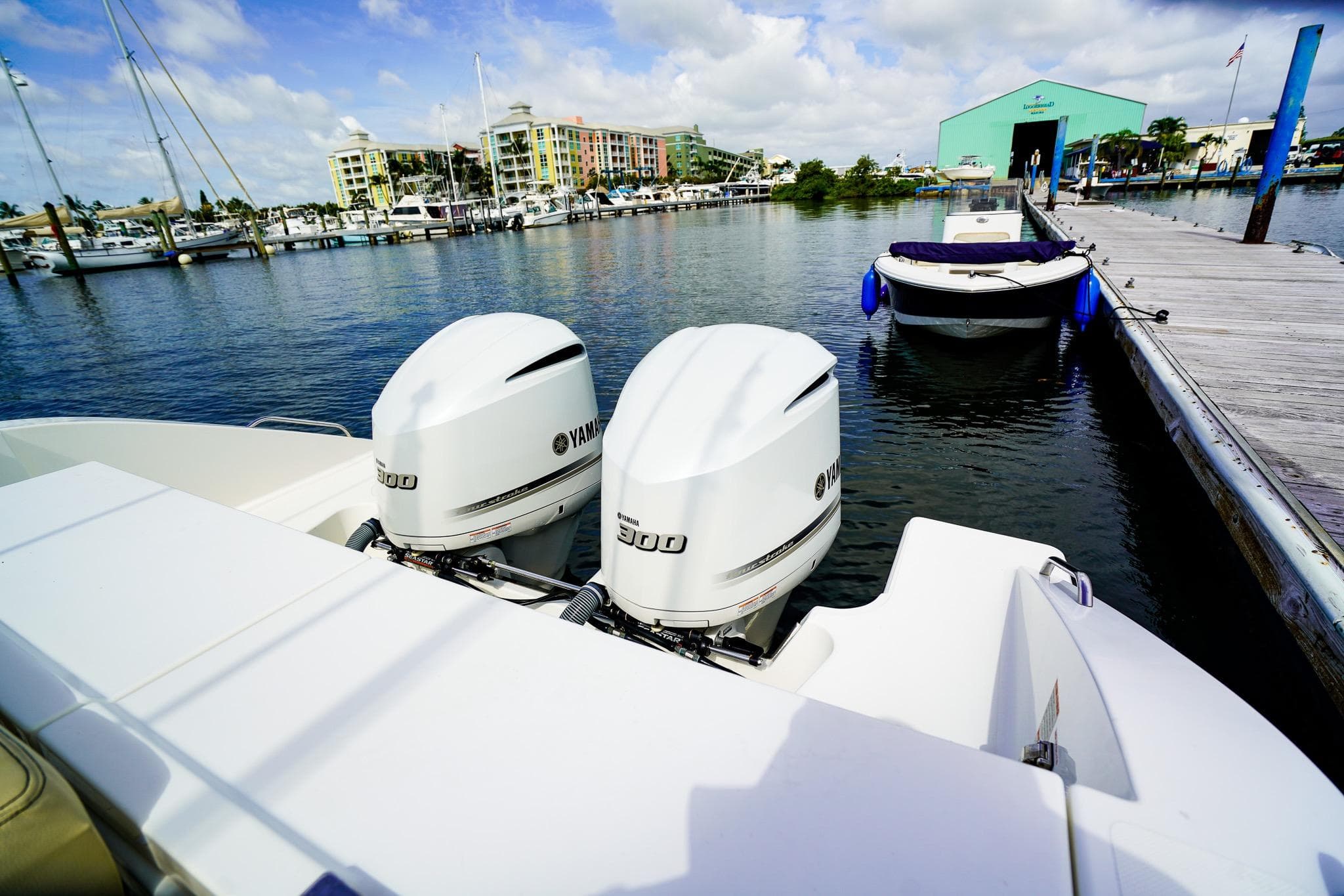 2020 Pursuit OS 325 Offshore boat with twin Yamaha 300 engines docked at marina.