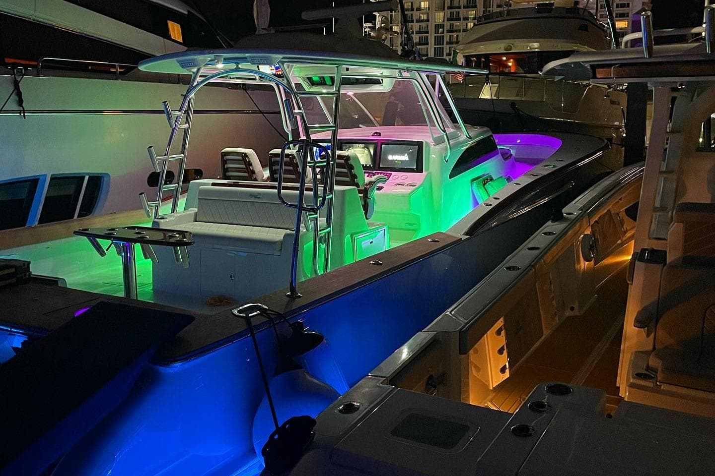 2025 Mystique Boatworks M48 Custom Carolina with vibrant LED lighting at night.