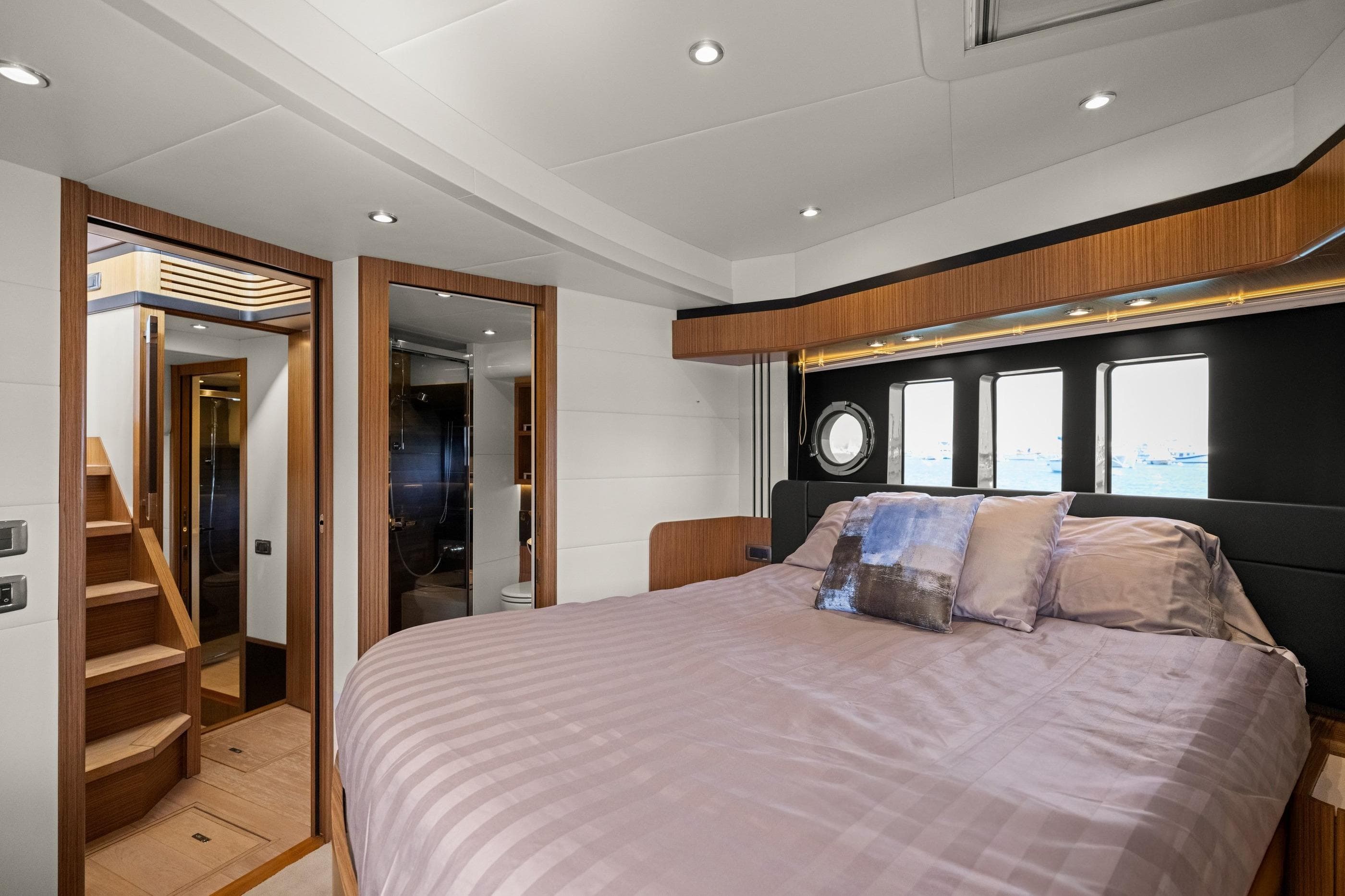 Luxurious bedroom interior of 2018 Absolute Navetta 52 yacht, featuring elegant wood finishes.