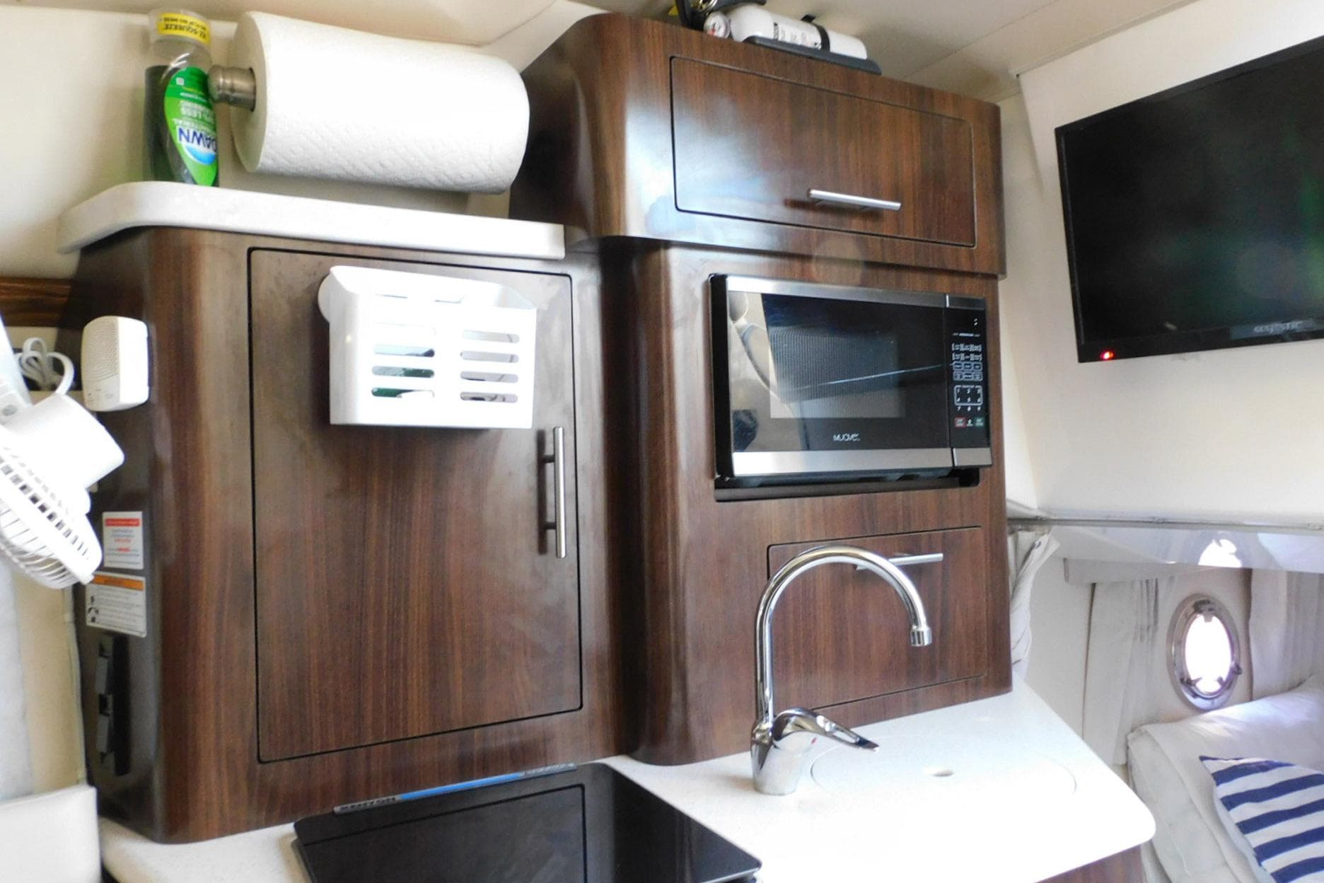 2019 Regal 28 Express boat interior with kitchenette, microwave, and TV.