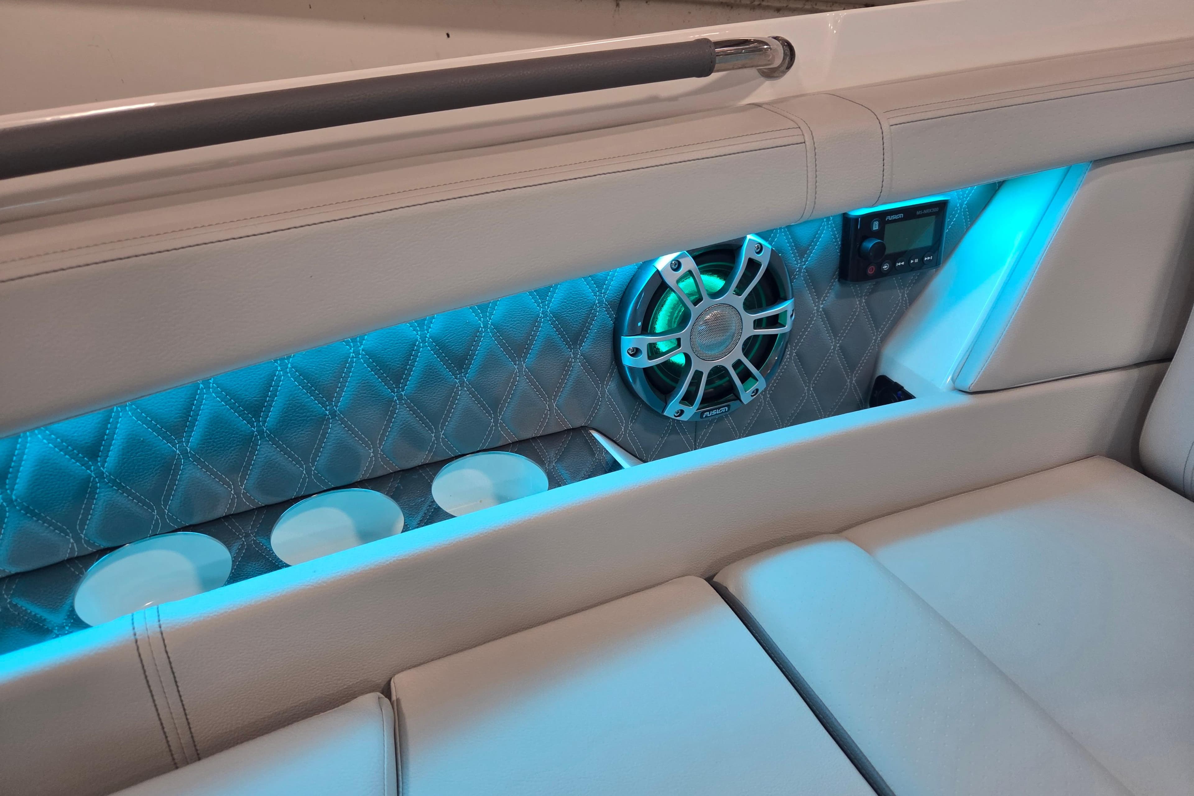 2023 Sea Ray SLX 350 interior with blue LED lighting, speaker, and cup holders.