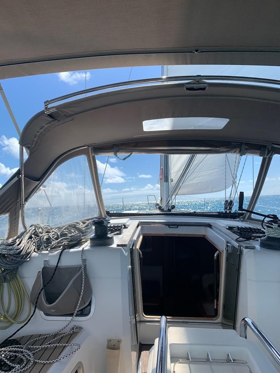 2015 Jeanneau Sun Odyssey 469 sailing on open water under clear blue skies.