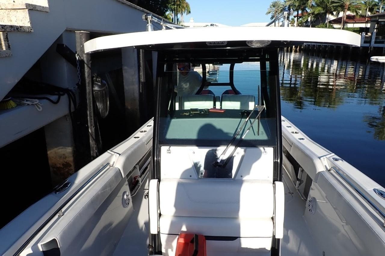2022 Blackfin 272 CC boat docked, featuring sleek design and spacious seating.