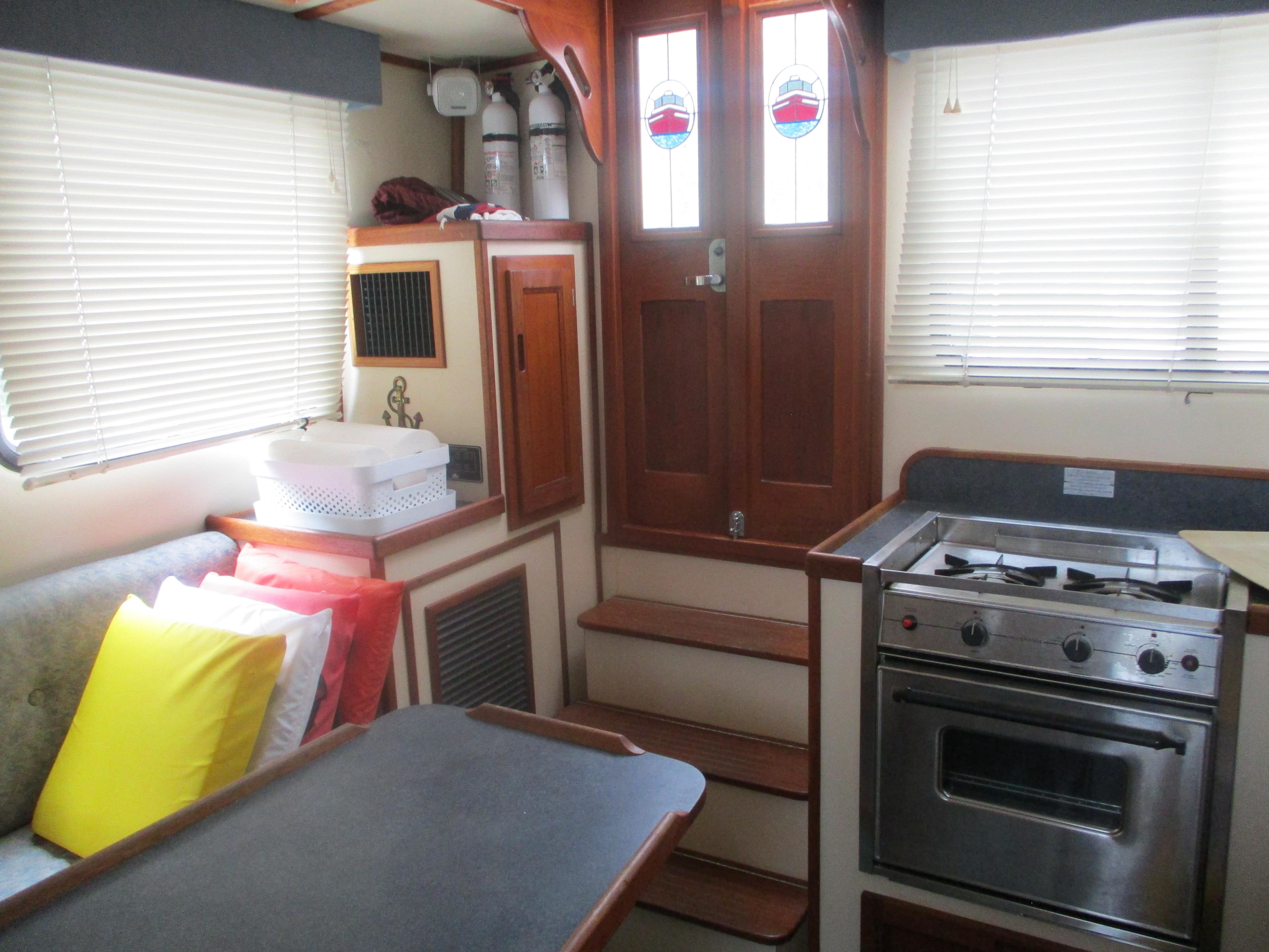 Interior of a 1998 Nordic Tug 32, featuring a cozy kitchen and dining area.