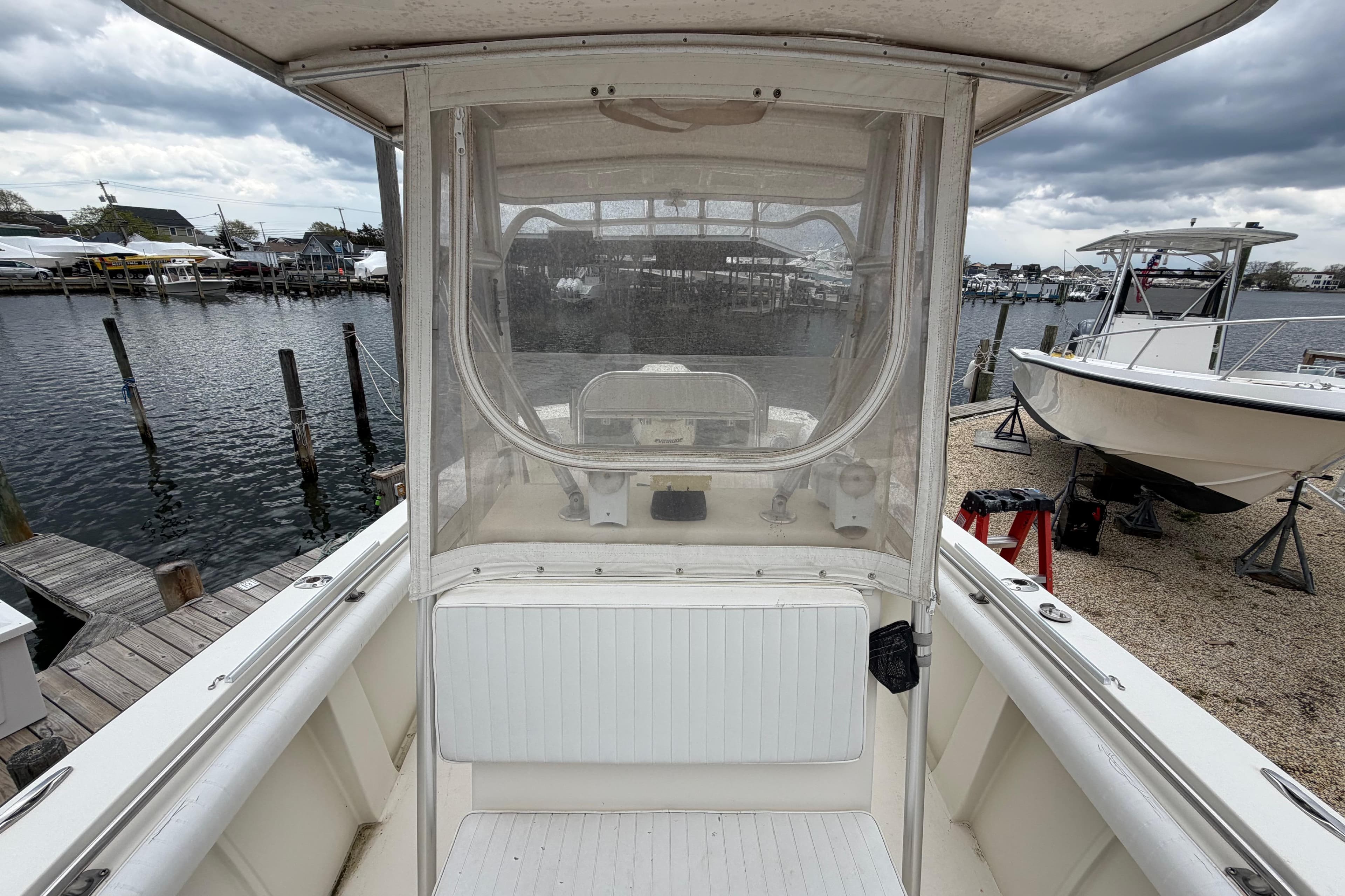 1985 SeaCraft SC 23 Classic boat docked at marina under cloudy skies.