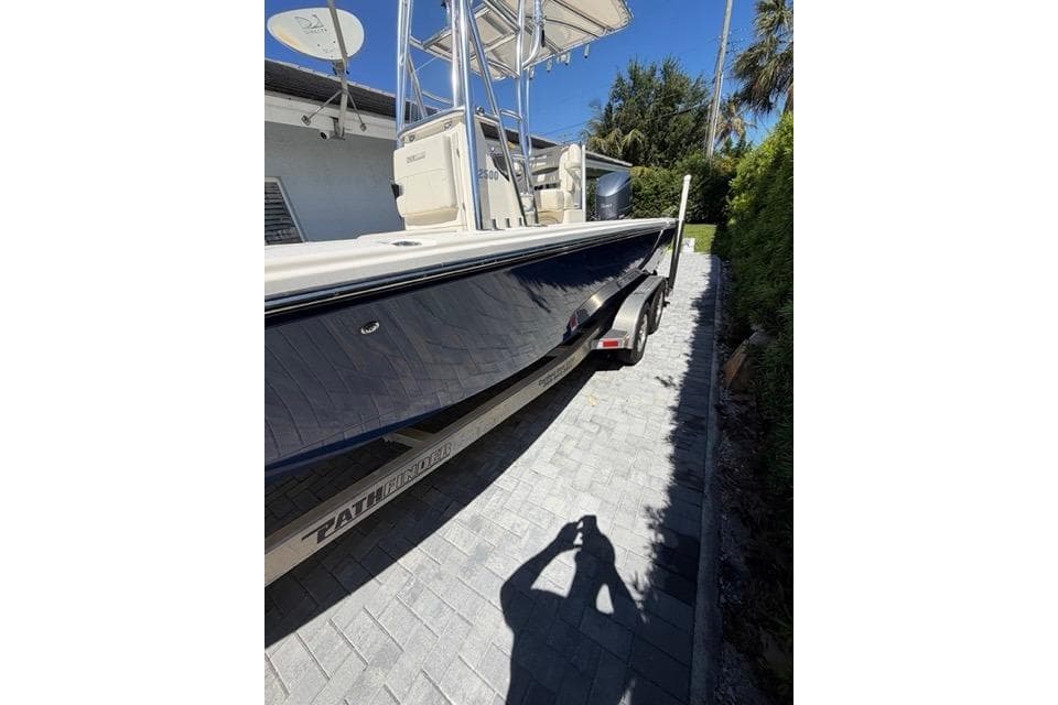 2018 Pathfinder 2500 Hybrid boat on trailer, parked on a paved driveway.