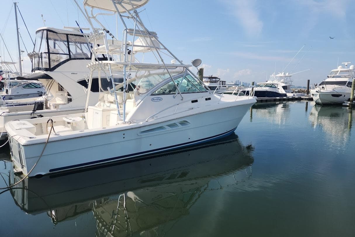 2006 Rampage 38 Express yacht docked in a marina, surrounded by other boats.