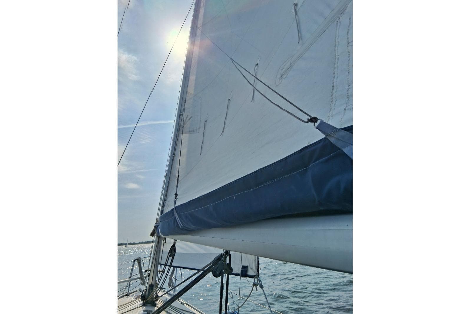Sailing on a 2006 Bavaria Cruiser 30 with sunlit sails and ocean view.