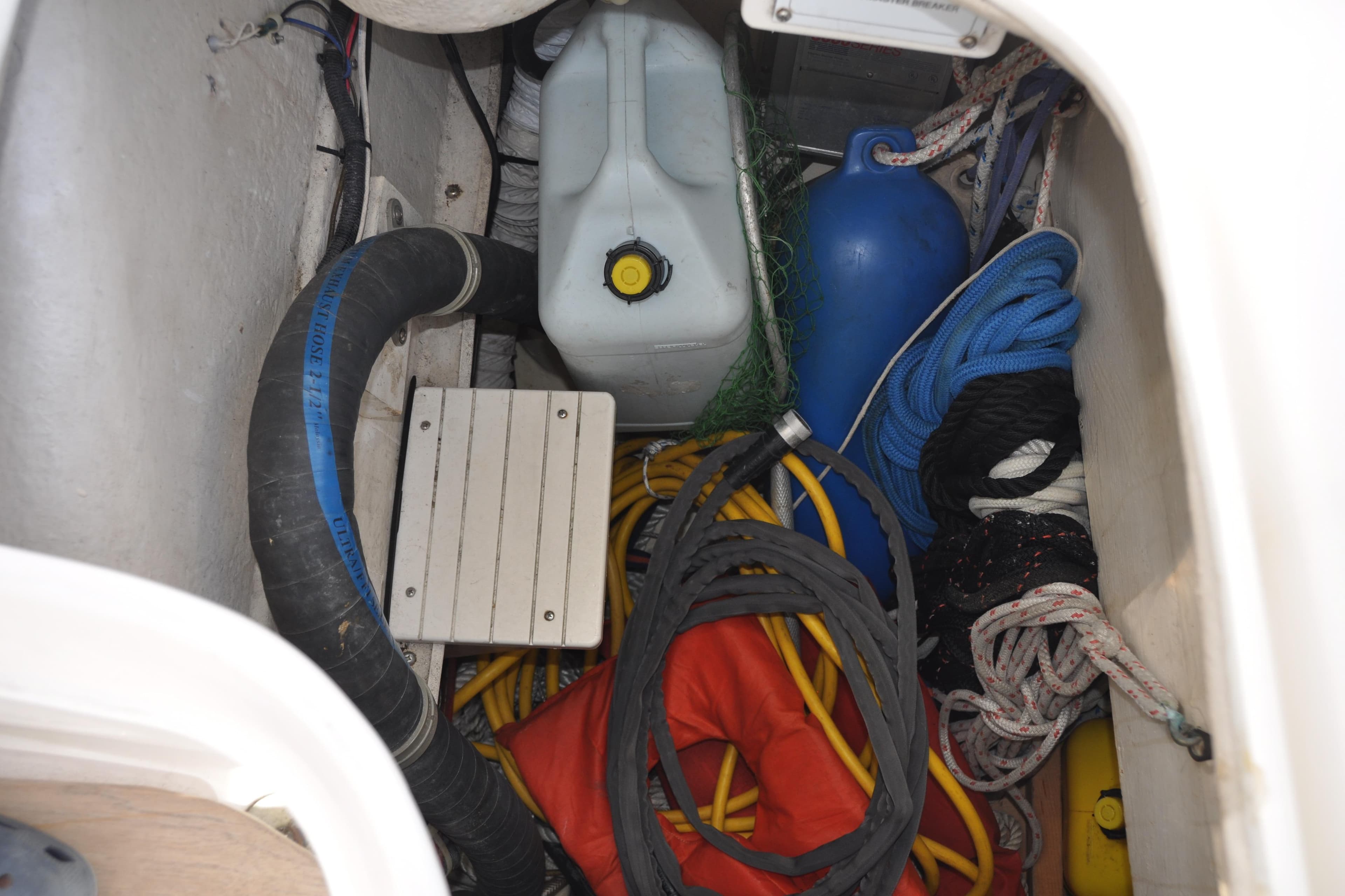 Storage compartment in a 2003 Catalina 387 sailboat with ropes, fender, and equipment.