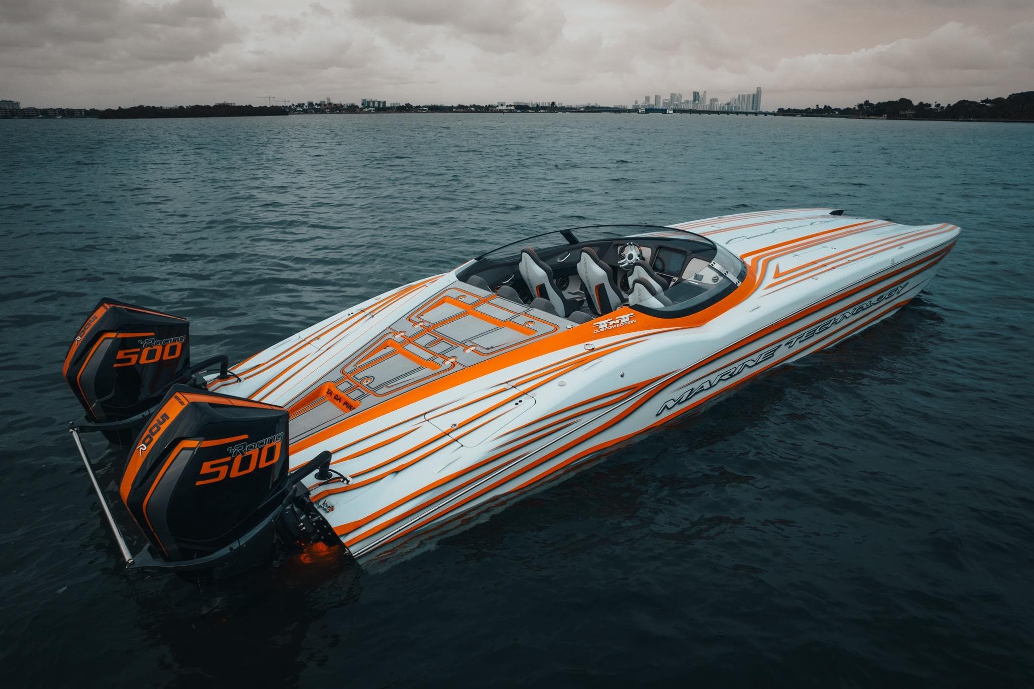 2024 MTI 390X powerboat with dual 500 engines on a calm water backdrop.