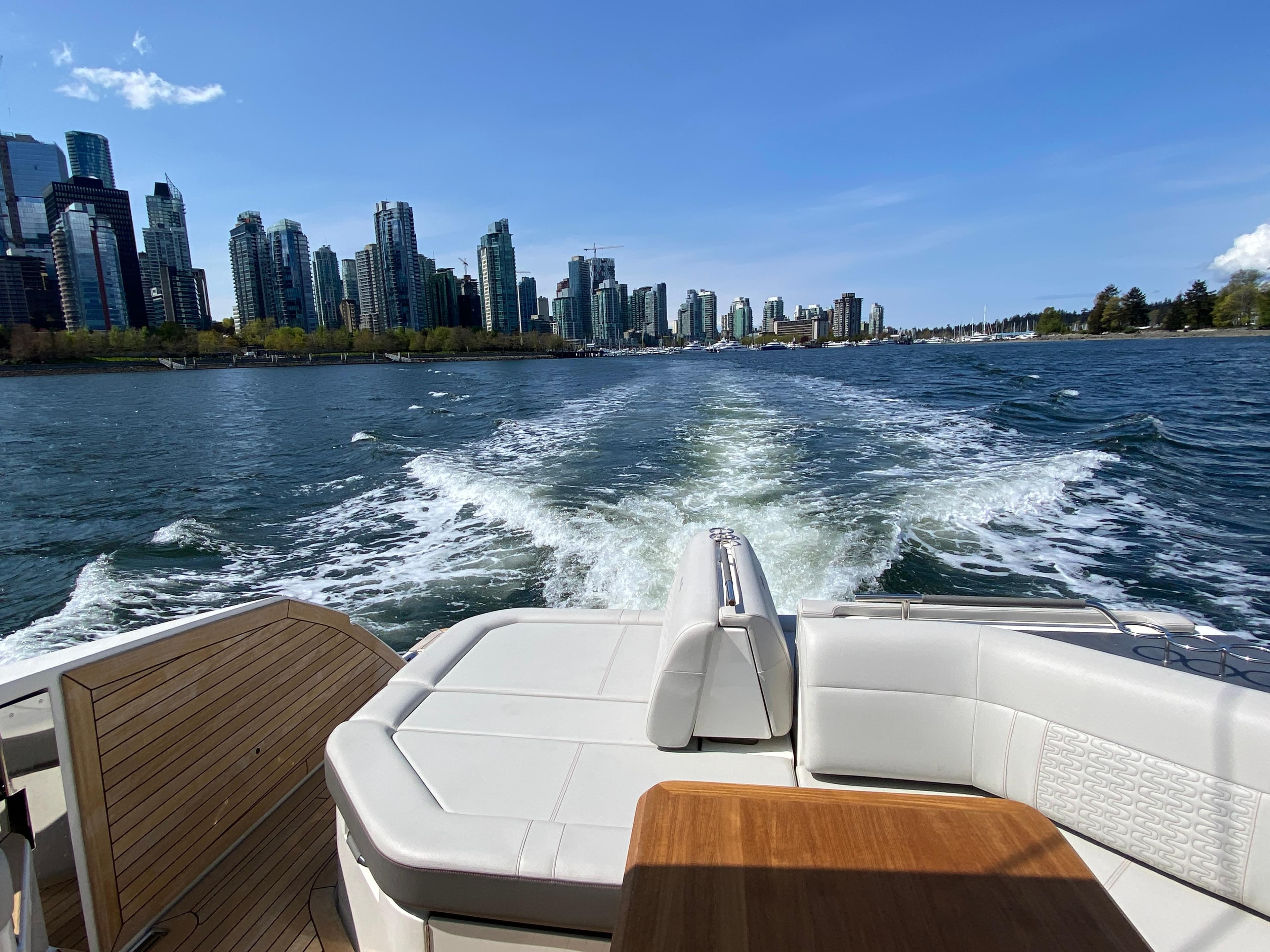 2023 Sea Ray SLX 400 cruising with city skyline in the background.