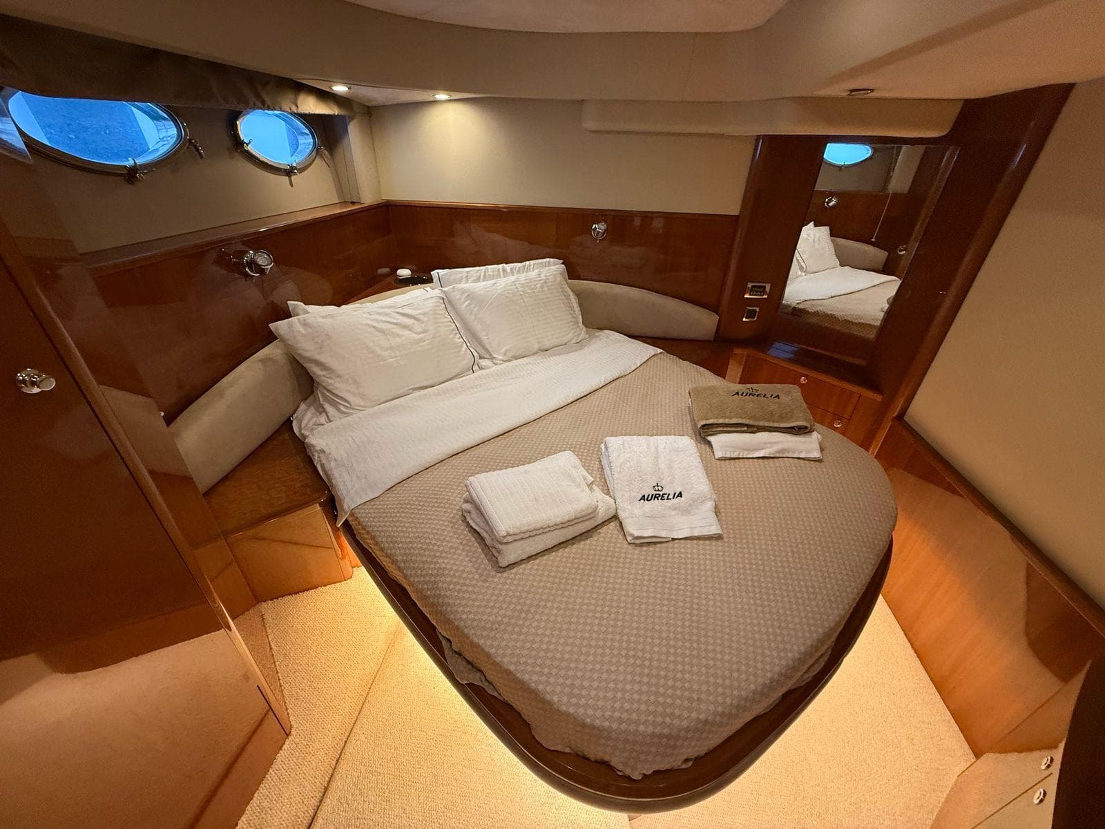 Luxurious cabin interior of 2009 Princess V58 yacht with cozy bed and elegant wood finish.