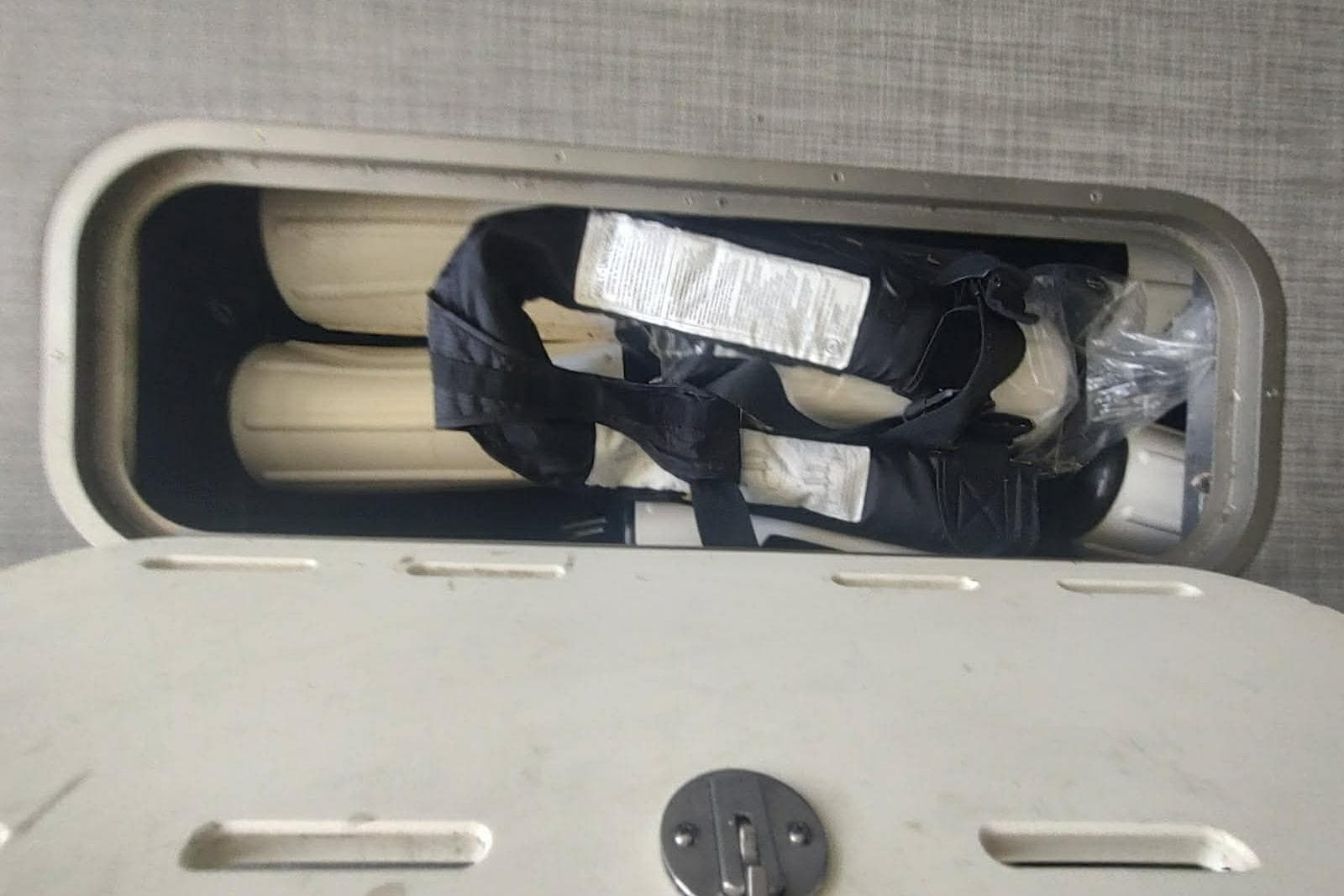Open storage compartment on 2023 PlayCraft 27 Infinity boat, containing life jackets.