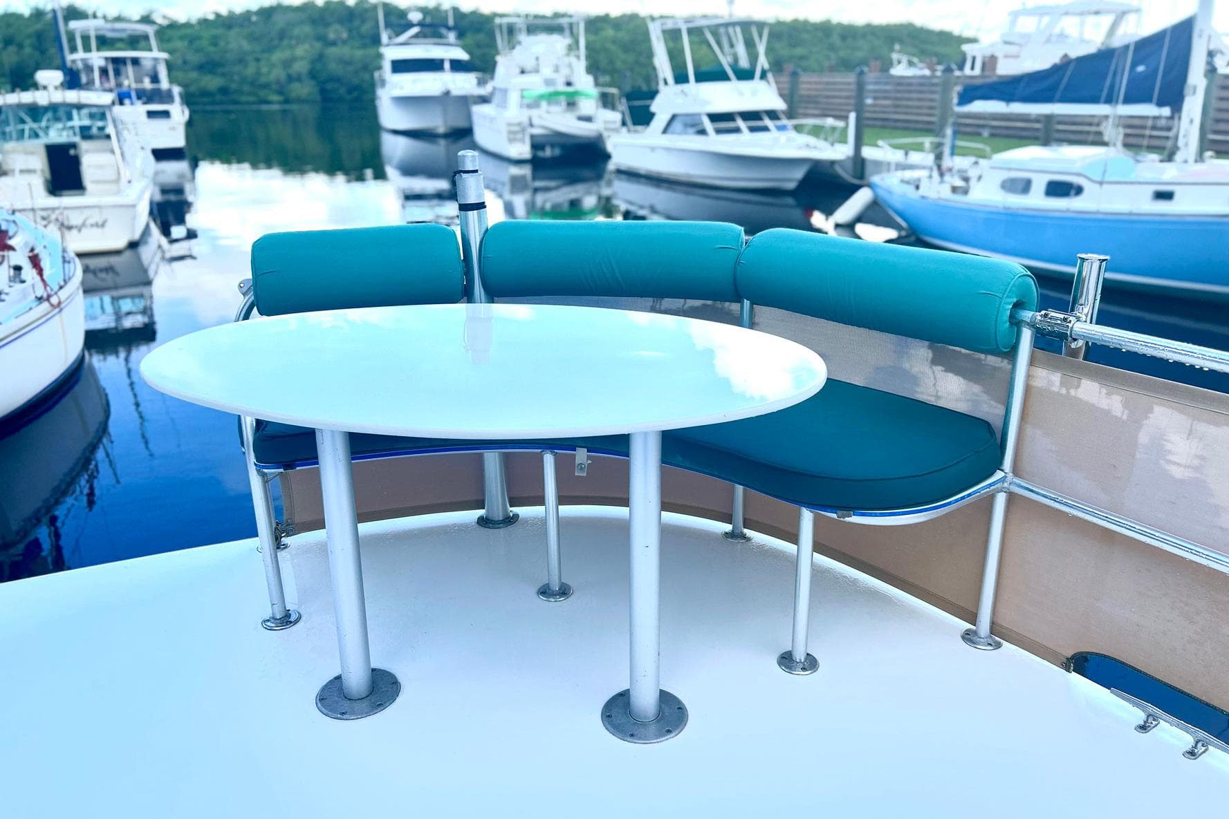 Outdoor seating area on a 2002 Custom 64 Stuart Catamarans, docked at a marina.