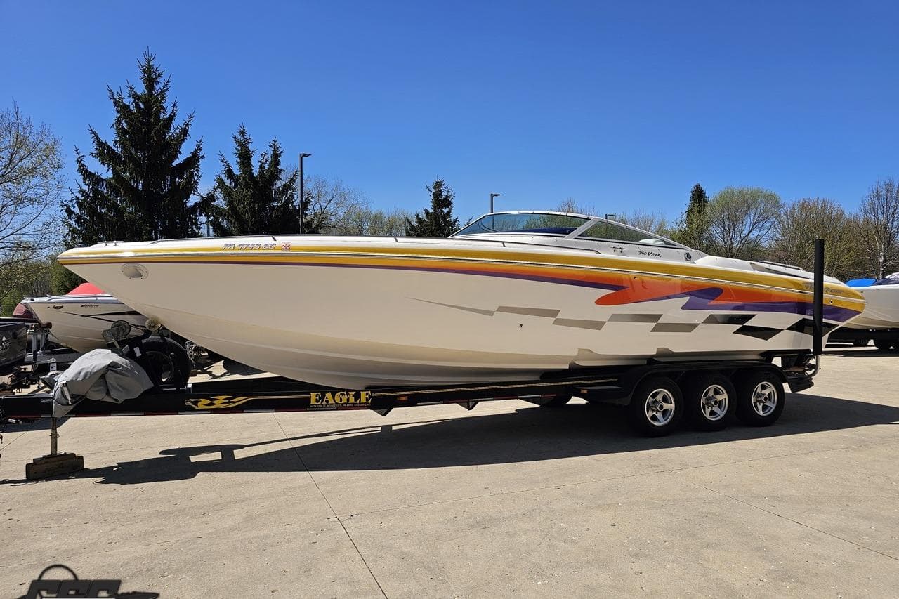 2001 Powerquest 340 Vyper speedboat on trailer, vibrant graphics, parked outdoors.