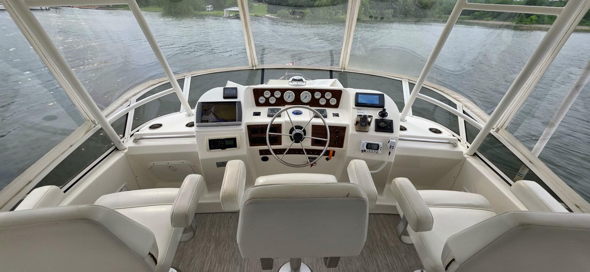 2000 Silverton 453MY yacht helm with three seats, overlooking calm waters.