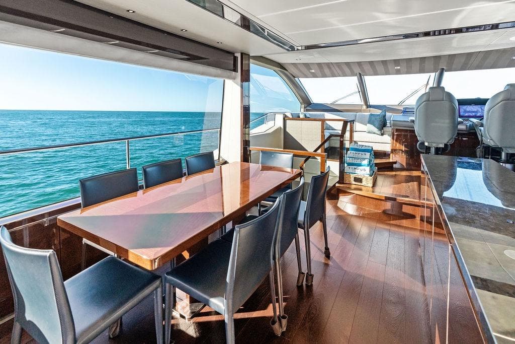 Luxurious interior of 2019 Sunseeker 76 Yacht with ocean view and elegant dining area.