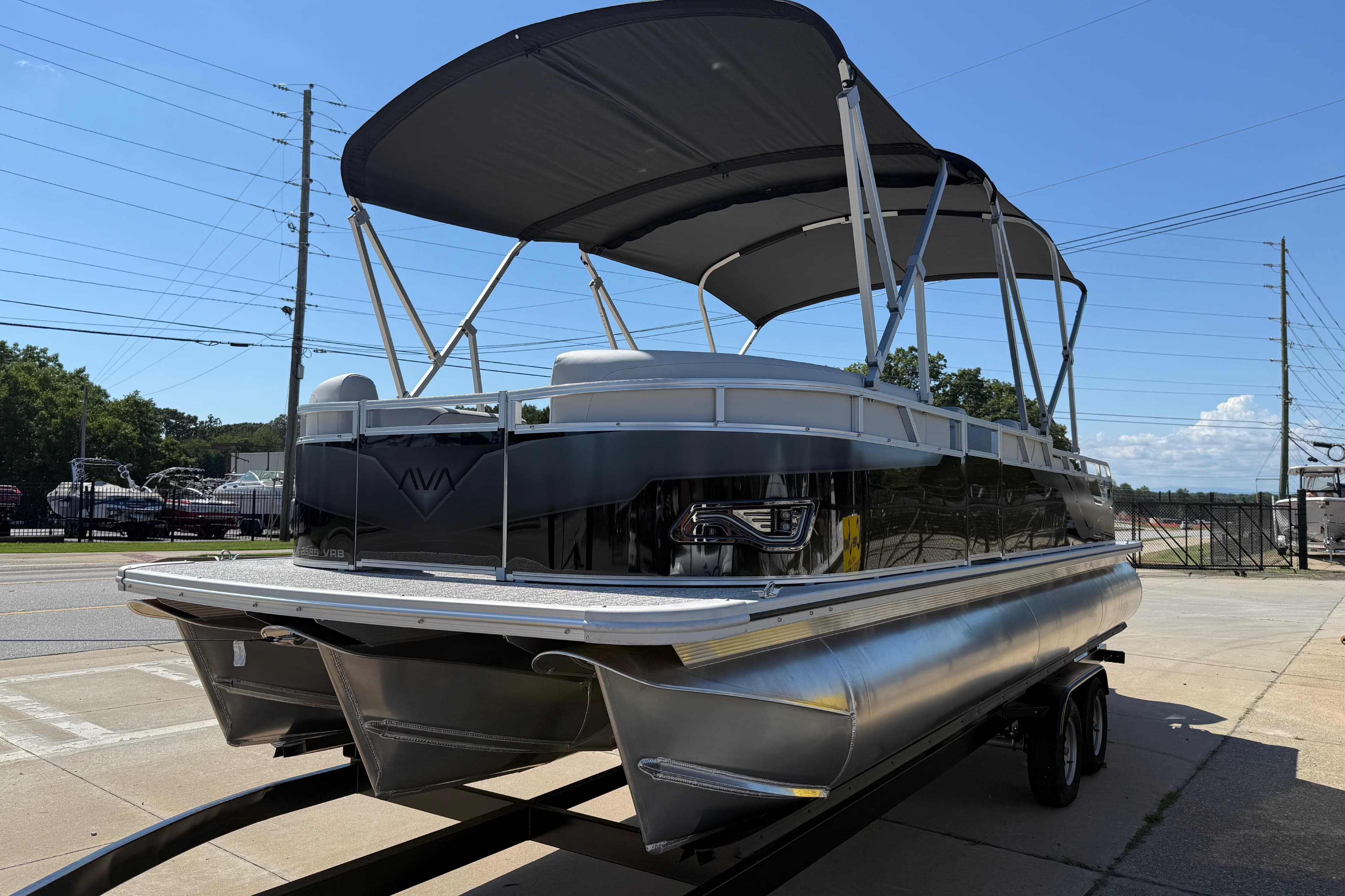 2026 Avalon Venture 85 Versatile Rear Bench pontoon boat on trailer, sunny day.