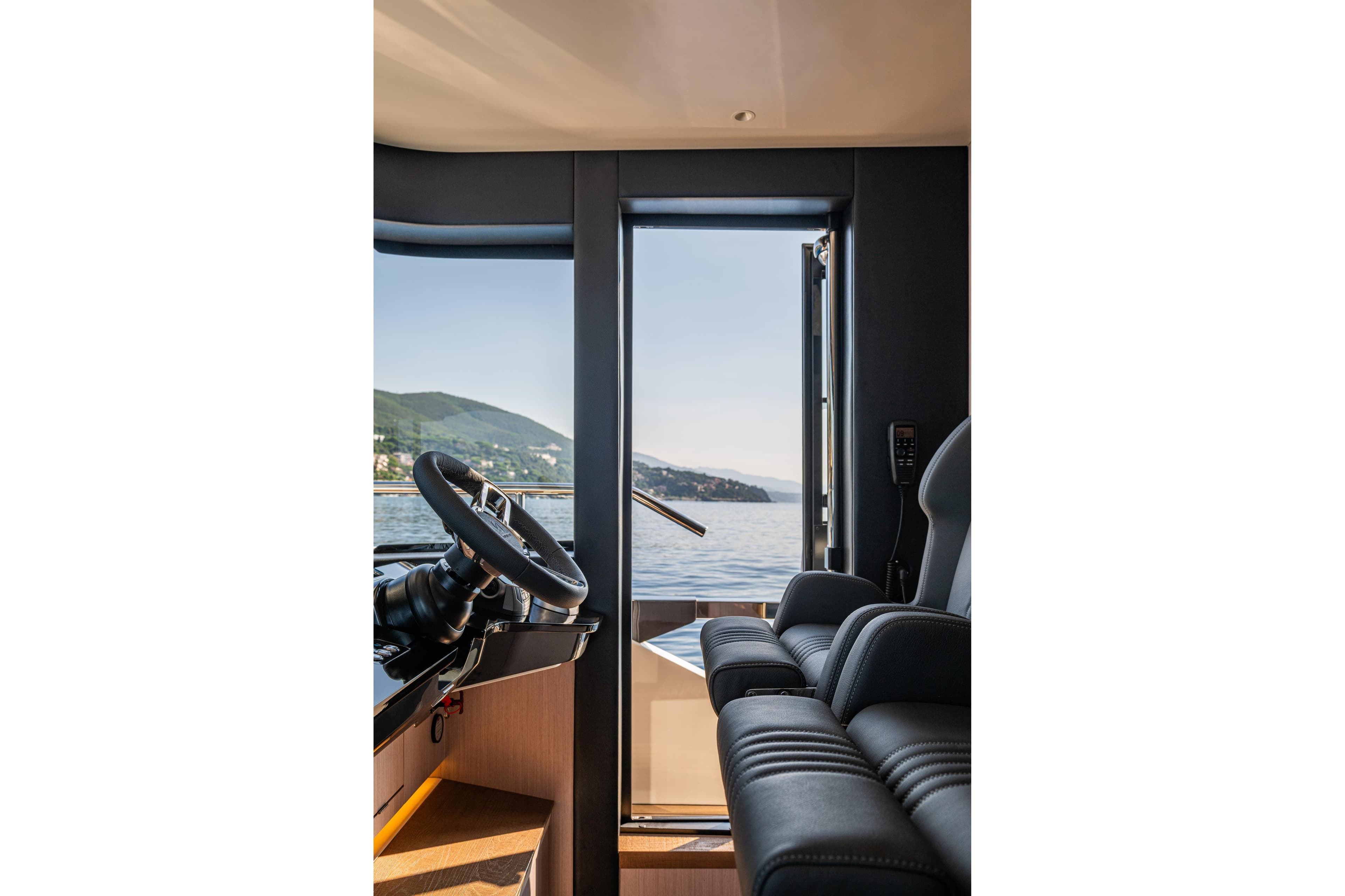 Interior view of 2026 Absolute 62' Navetta yacht helm with scenic ocean backdrop.