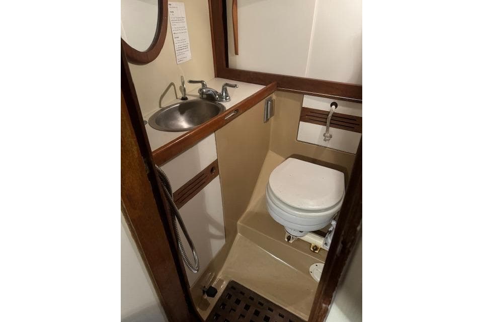 Compact bathroom in 1984 Sea Sprite 34 Yawl, featuring sink and marine toilet.