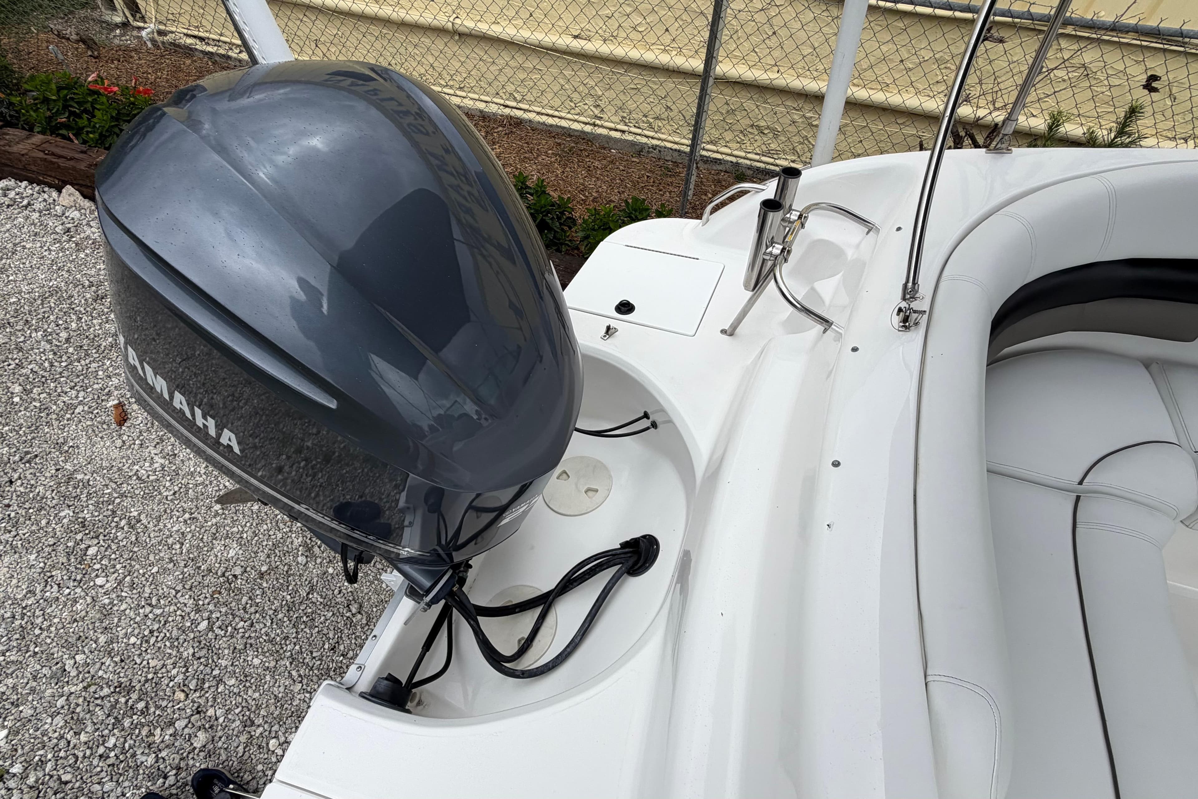 2013 Hurricane SunDeck 237 OB boat with Yamaha outboard motor, white seating, and sleek design.
