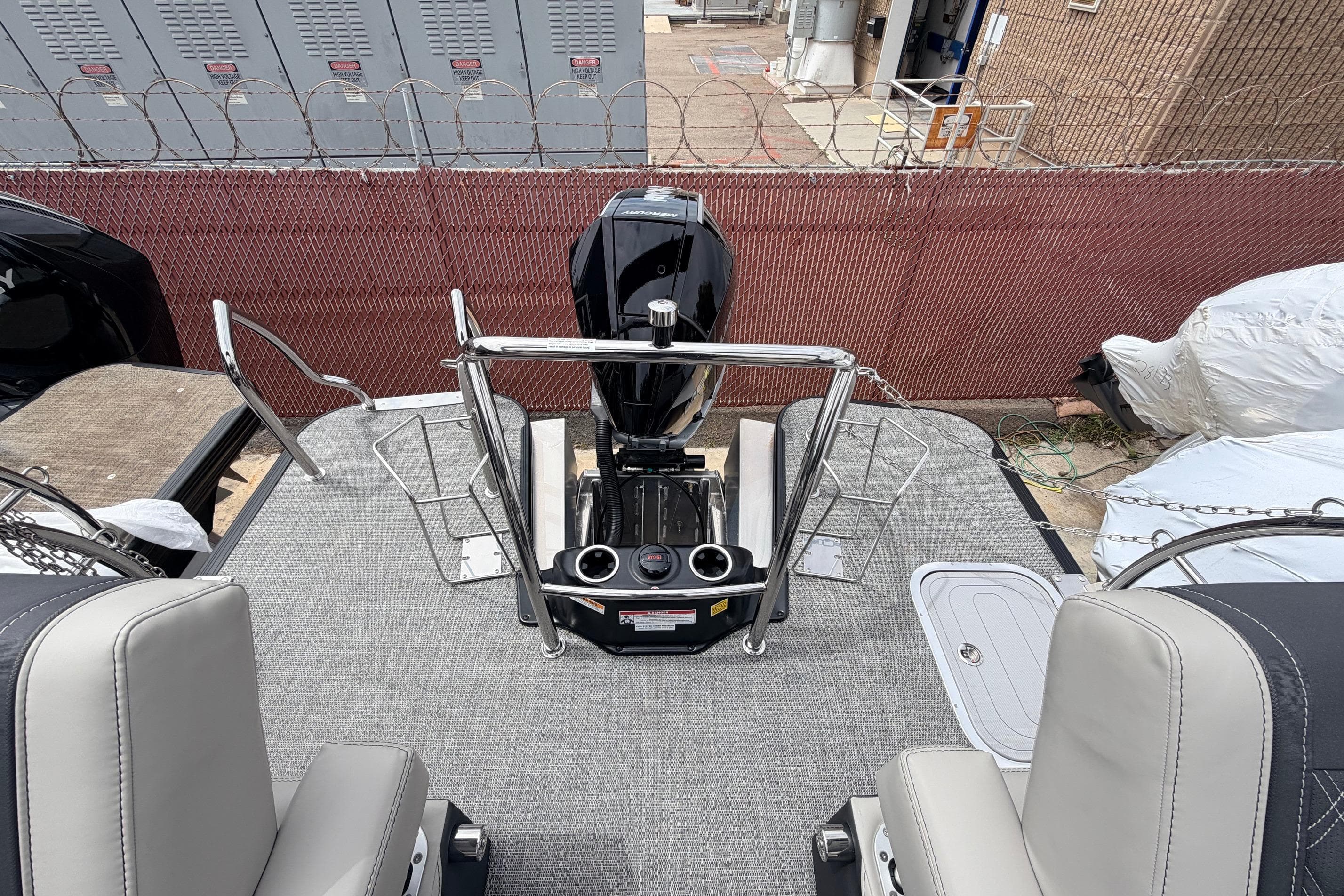 2026 Barletta Lusso 23M boat interior with motor, seating, and safety railings.