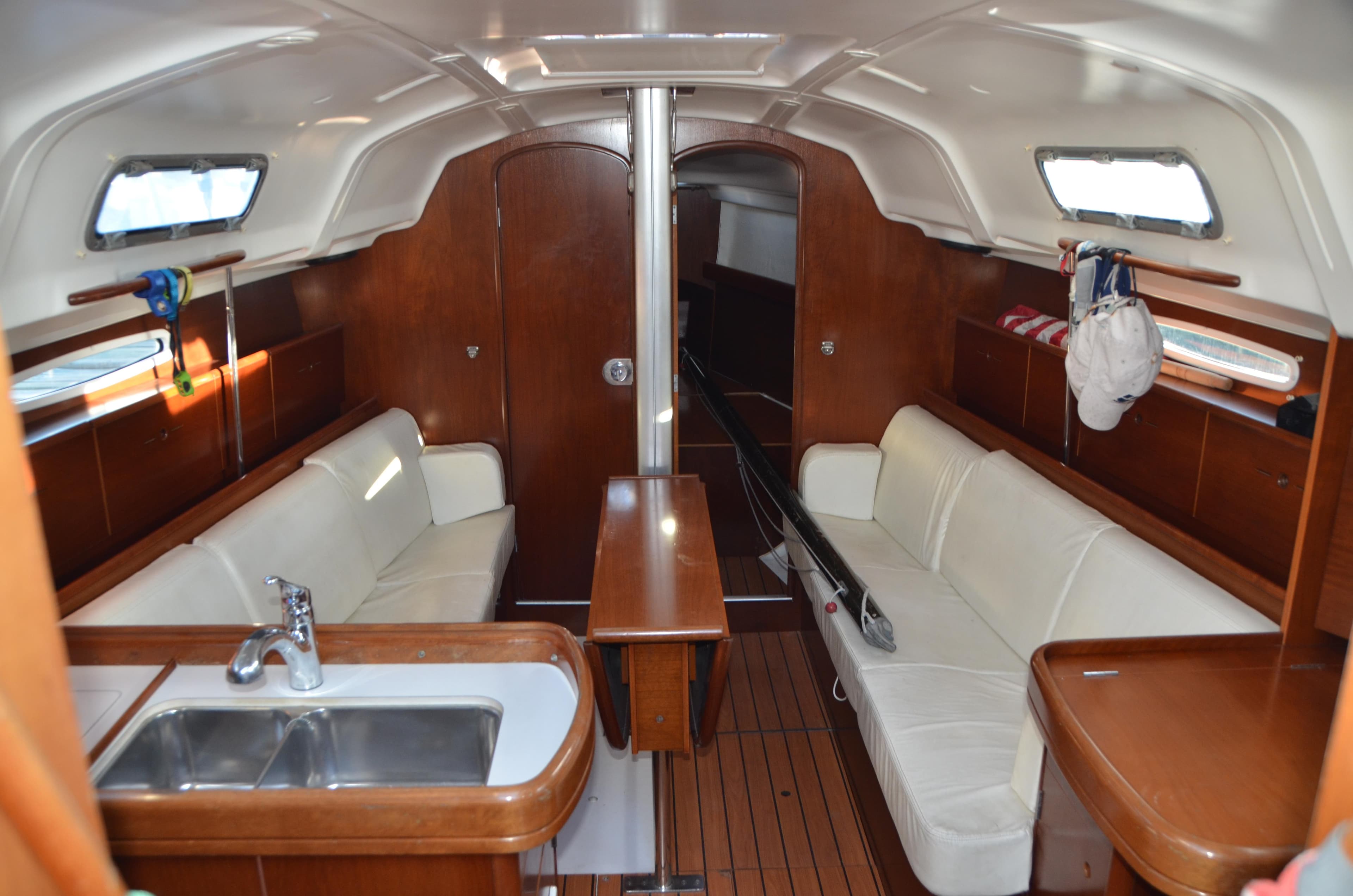 Interior of 2002 Beneteau First 36.7 sailboat with wood finish and white seating.