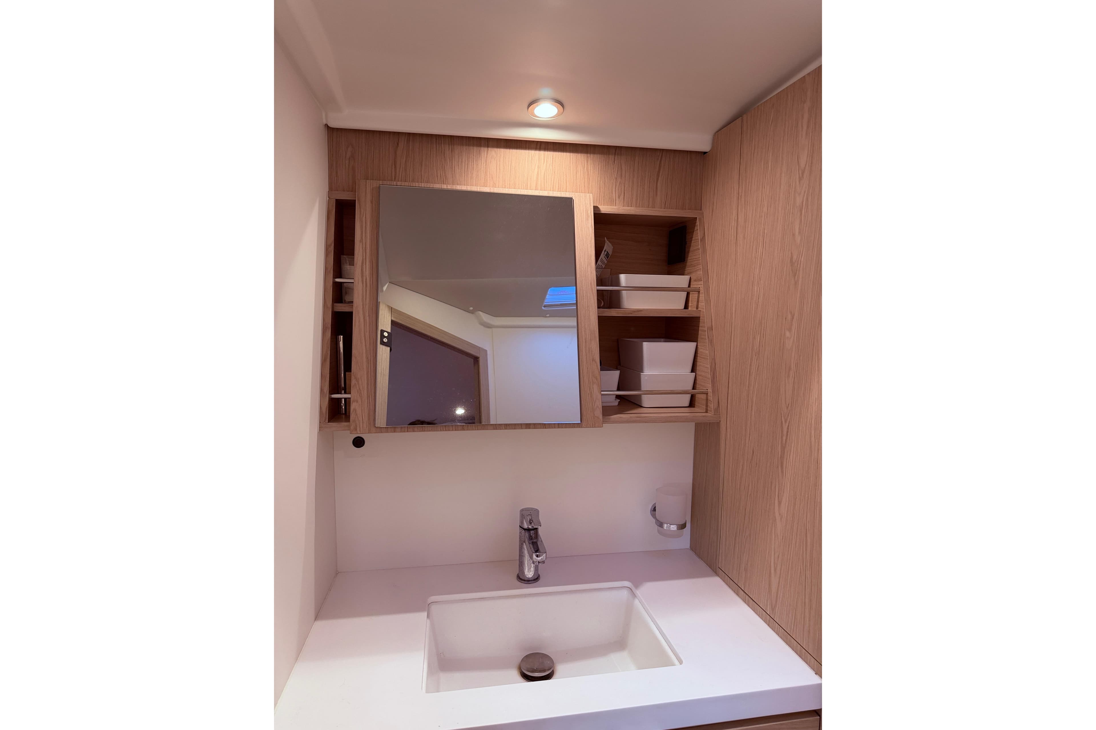 Modern bathroom vanity in 2022 Beneteau Oceanis Yacht 54, featuring sleek sink and wooden cabinetry.