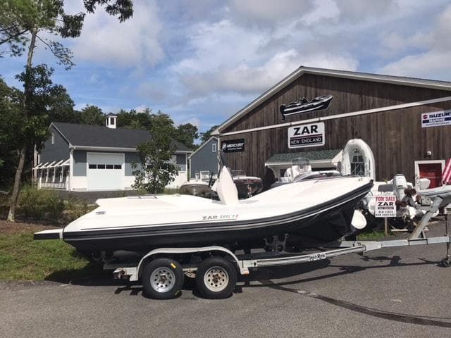 2024 Zar Formenti 59 SL boat on a trailer outside a dealership.
