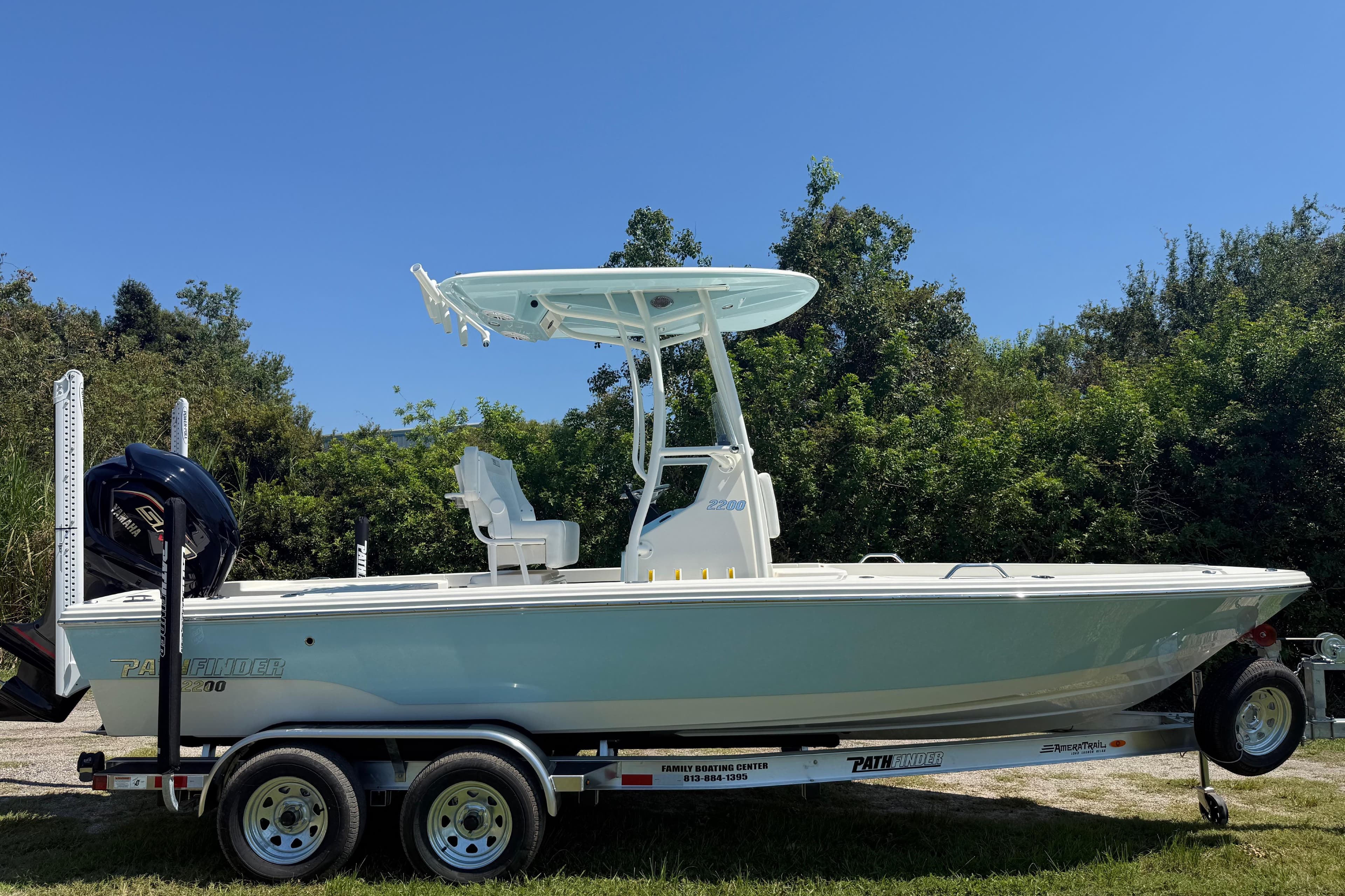 2026 Pathfinder 2200 TRS boat on trailer, parked outdoors with lush greenery background.