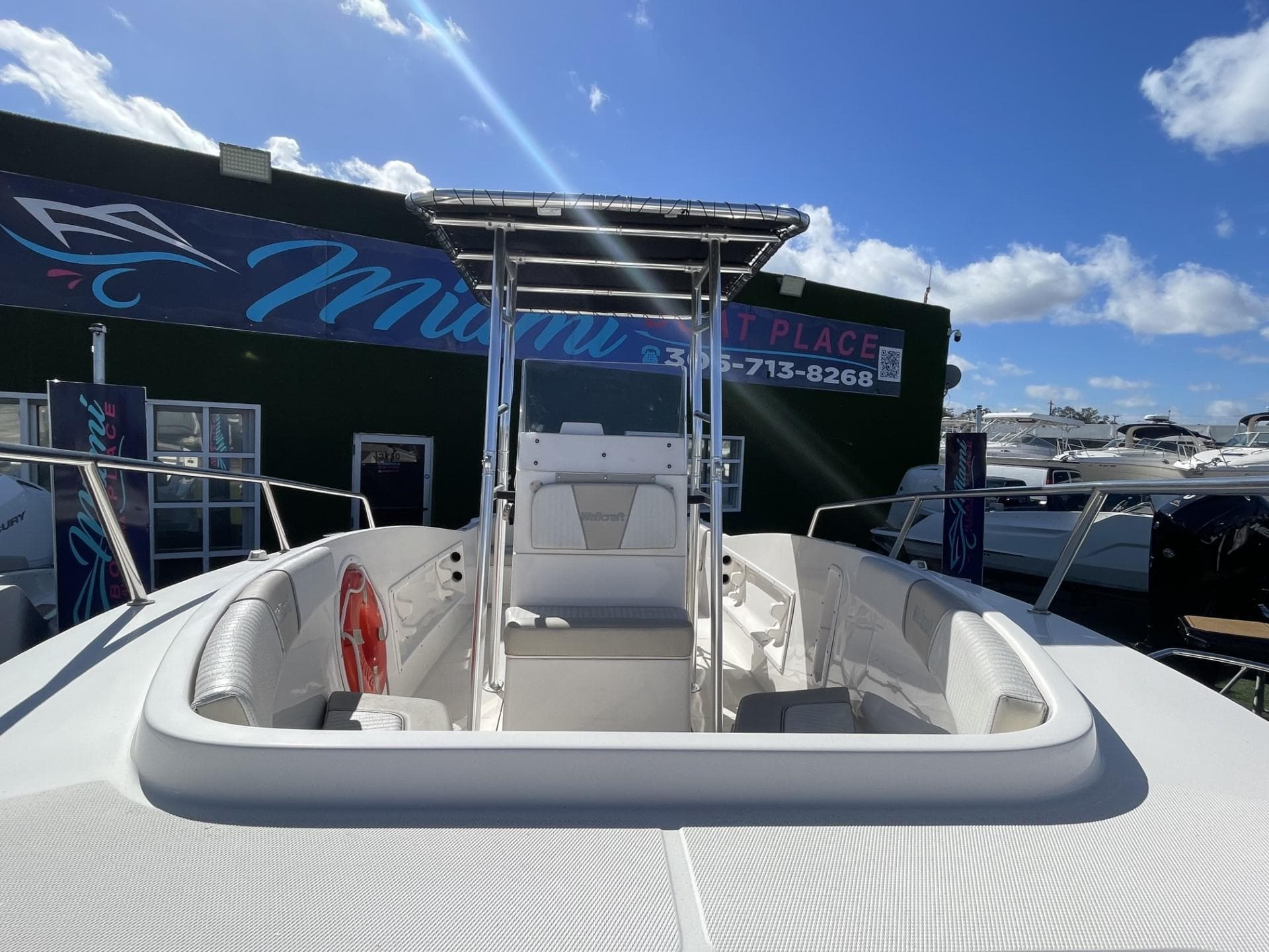 2022 Wellcraft 220CC center console boat at a dealership under a clear blue sky.
