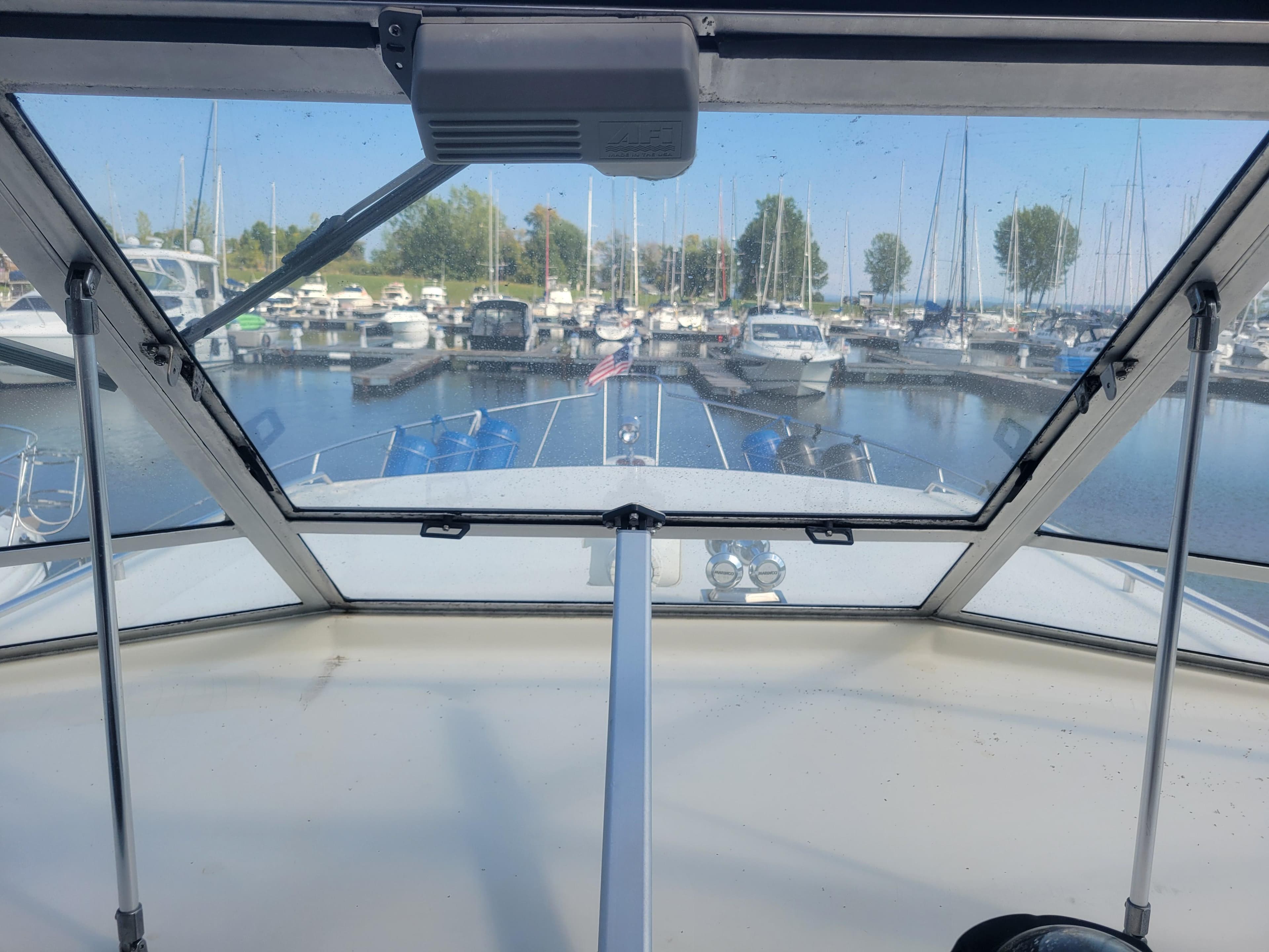 1986 Chris-Craft 381 Catalina yacht docked in a marina, viewed from the helm.