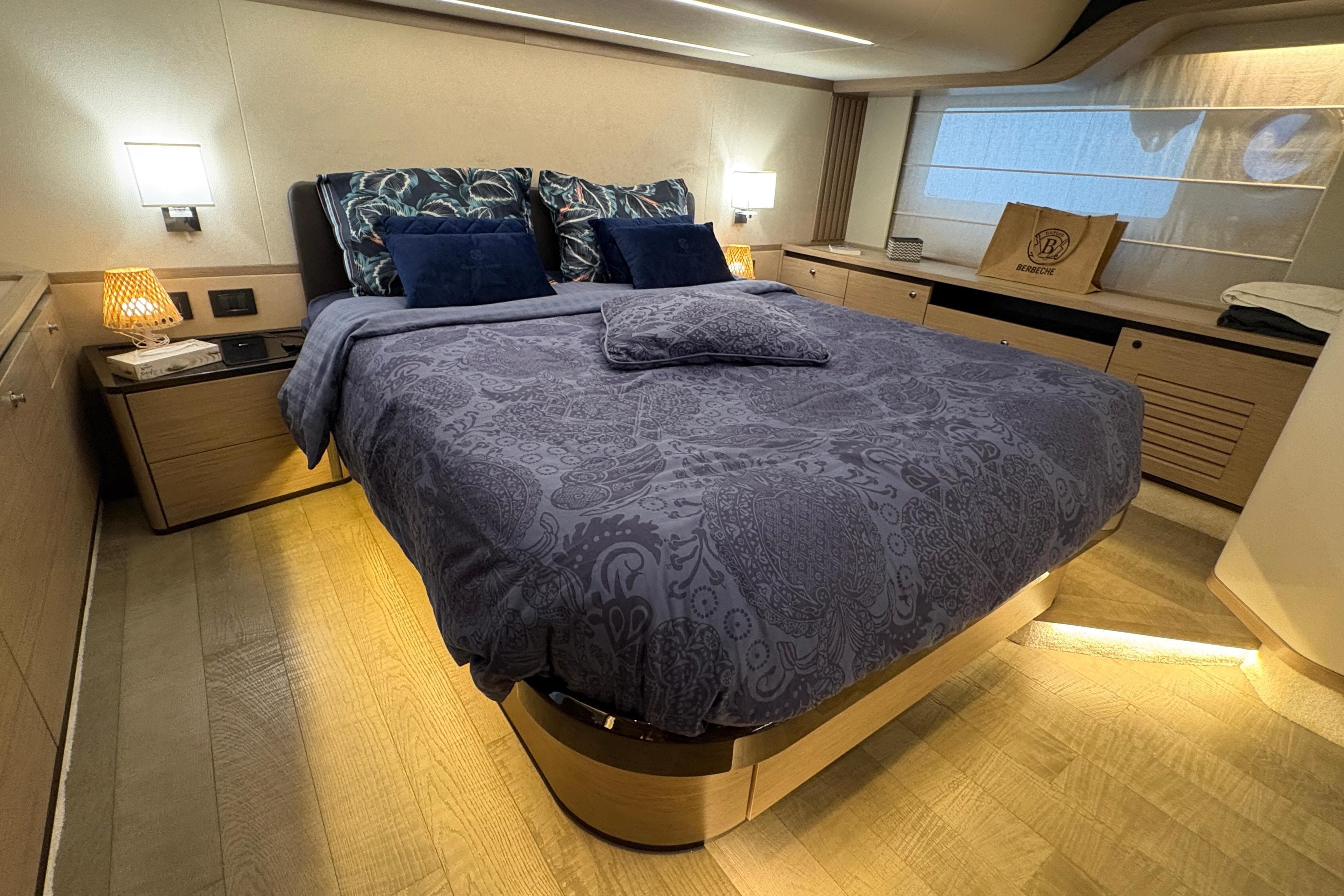 Luxurious bedroom interior of 2020 Absolute Navetta 52 yacht with elegant bedding and ambient lighting.