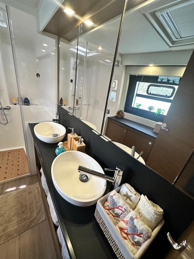 Modern bathroom in 2021 Nautitech 46 Fly catamaran with dual sinks and large mirror.