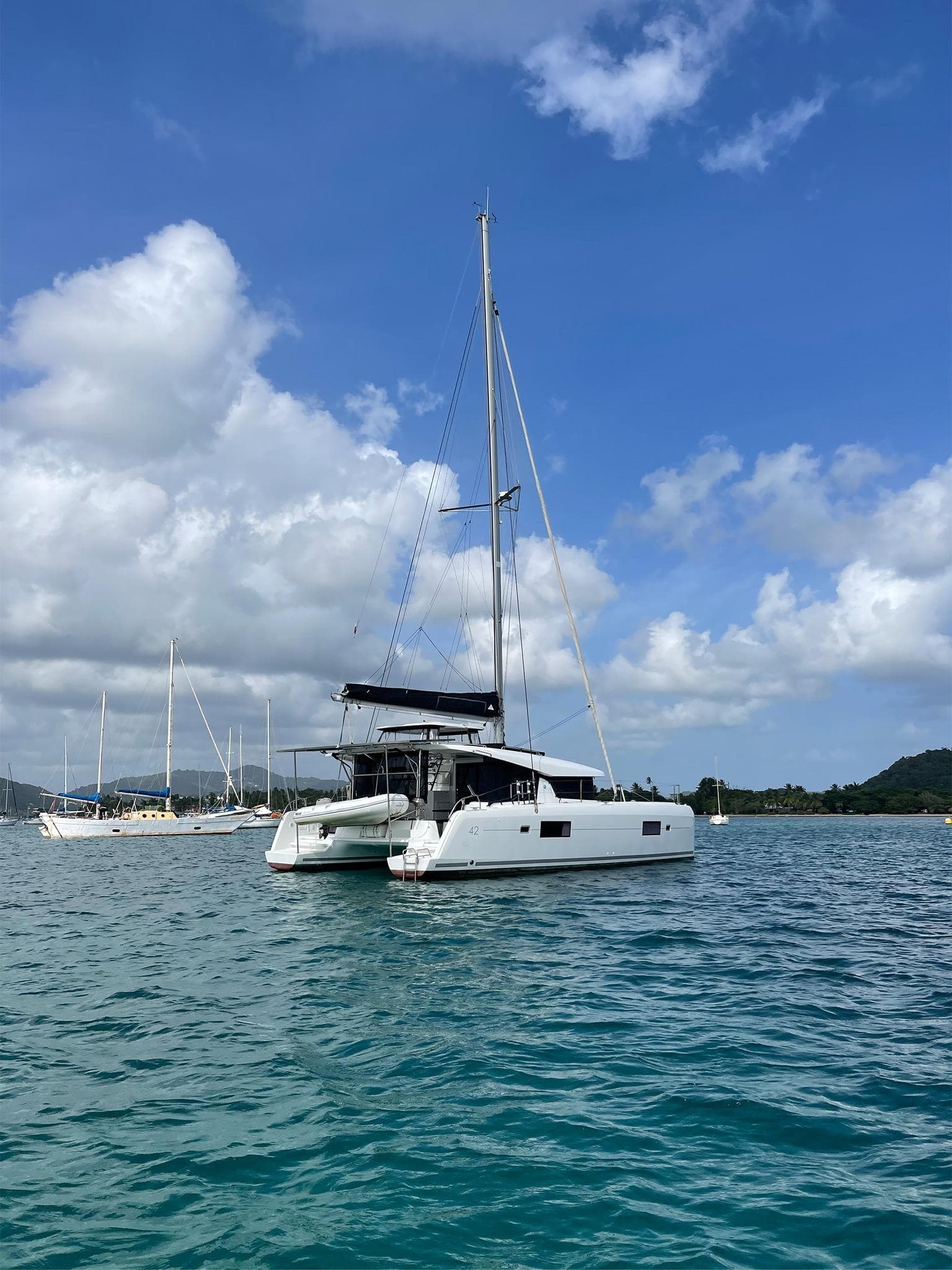 2017 Lagoon 42 catamaran sailing on a calm sea under a blue sky.