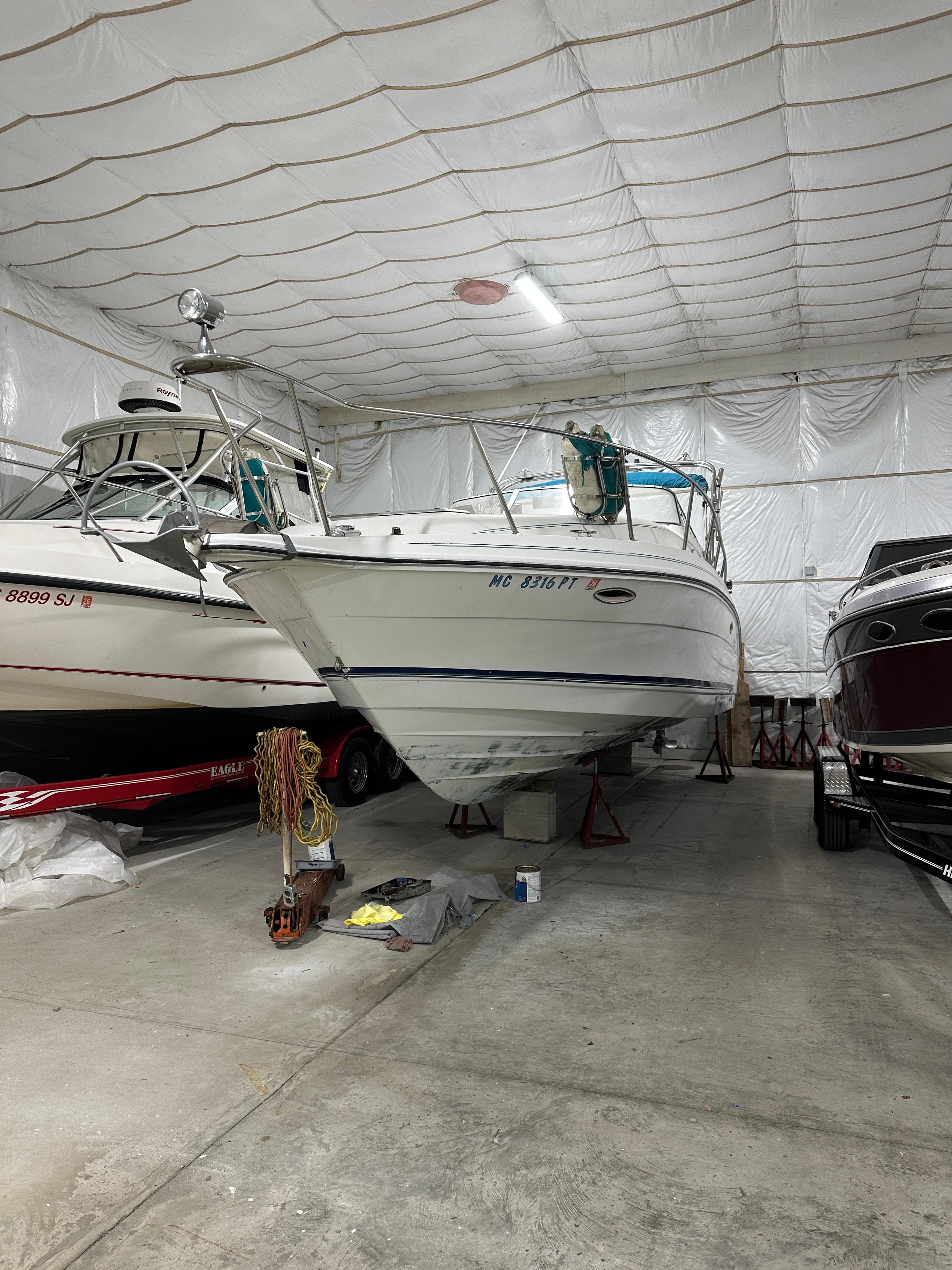 1993 Rinker 280 Fiesta Vee boat stored indoors, surrounded by other boats.