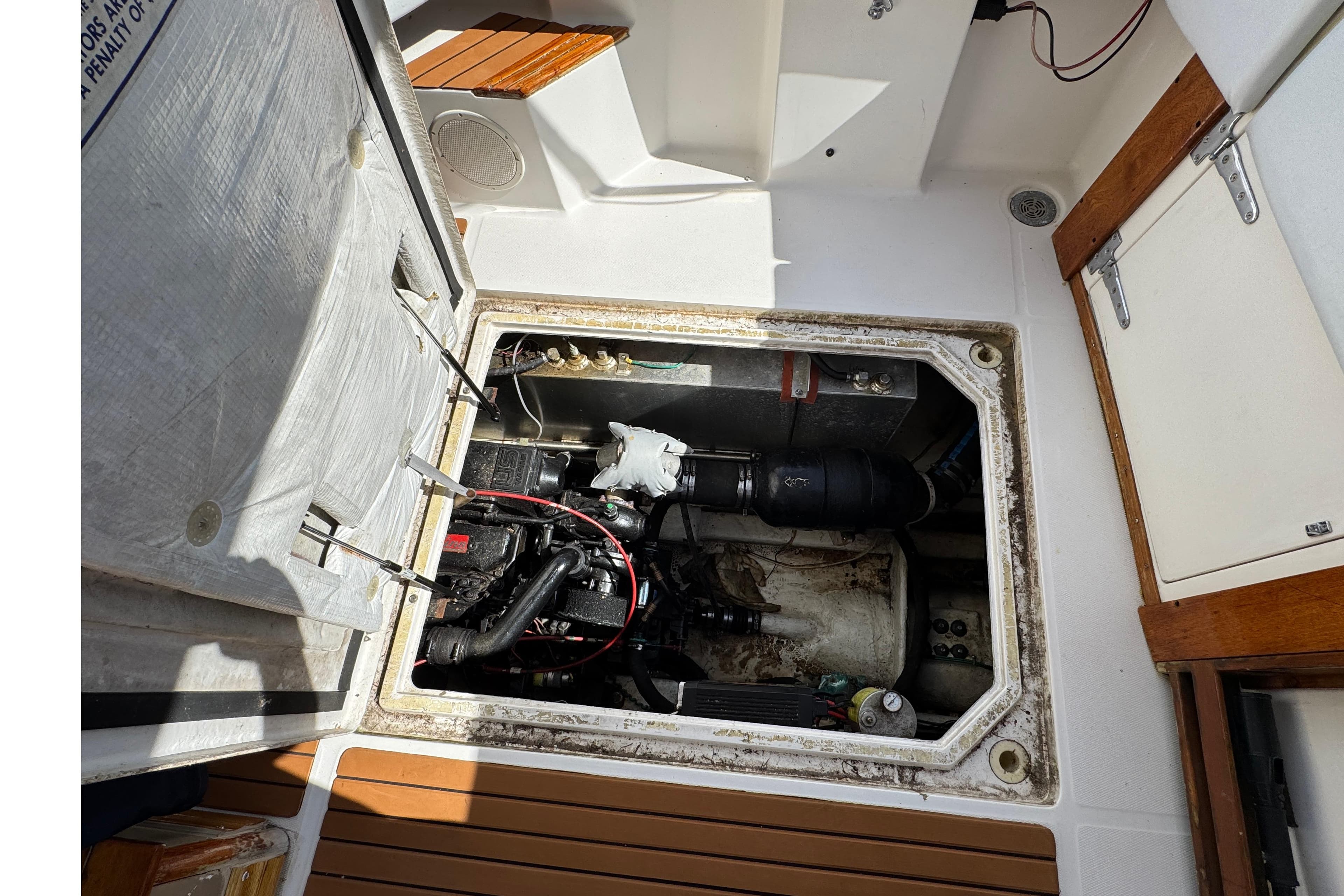 Engine compartment of a 1995 Bayliner 3288 Motoryacht, showing mechanical components and storage area.